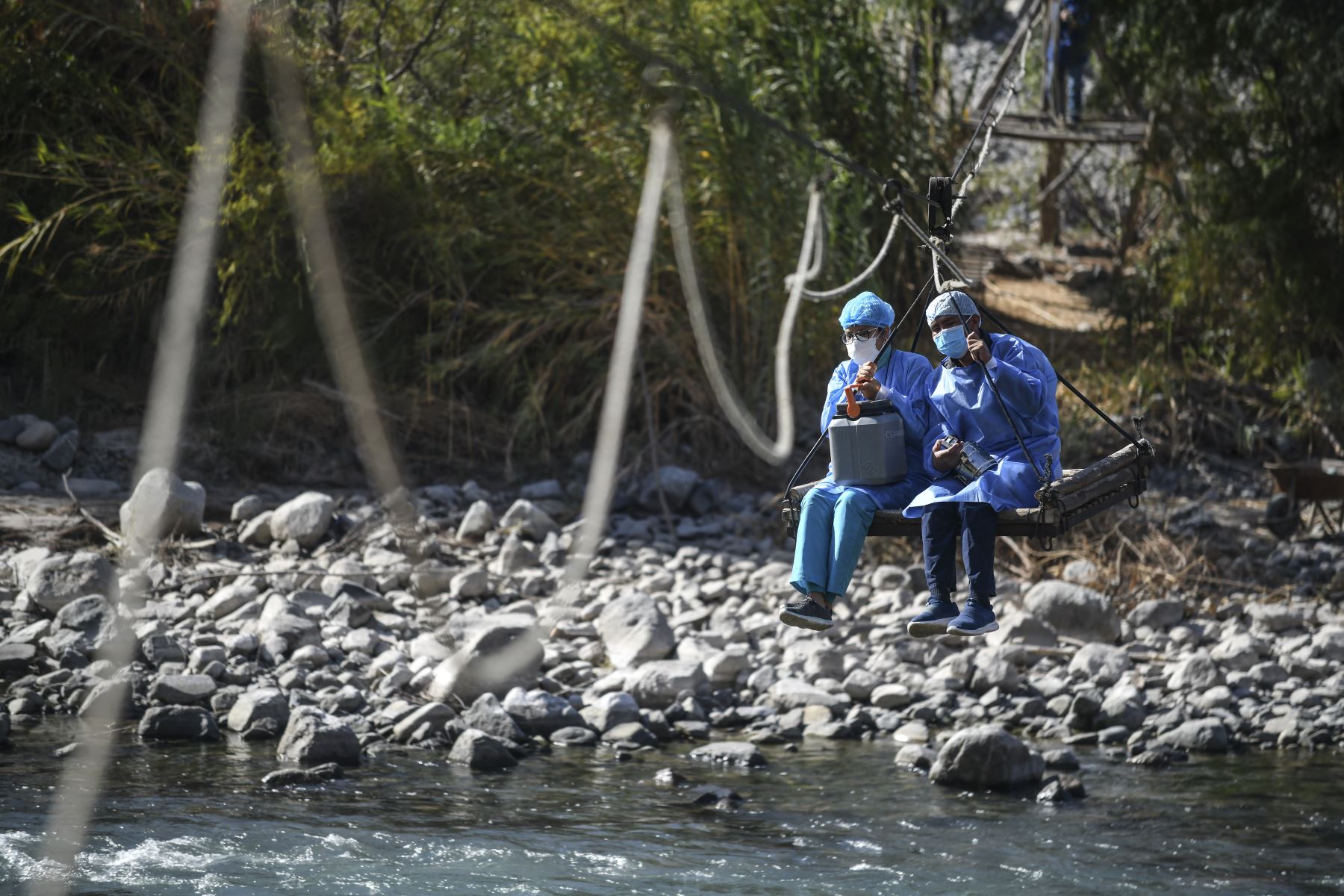 Trabajadores de salud cruzan el río Camaná para inocular a ancianos con dosis de la vacuna Pfizer-BioNTech contra COVID-19, en Arequipa, sur de Perú