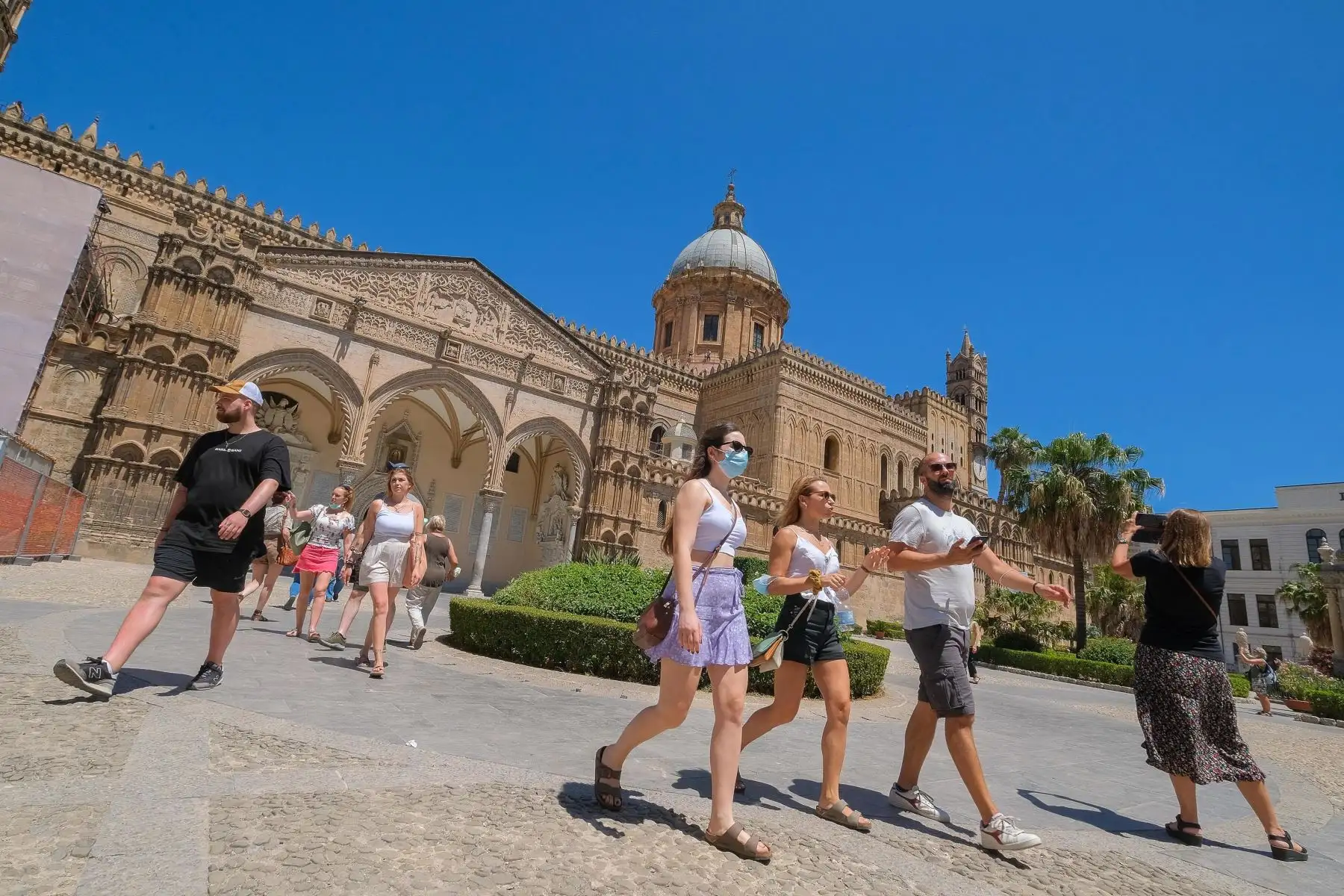 Turistas con el telón de fondo de la Catedral en el centro histórico de Palermo, isla de Sicilia, sur de Italia. Foto: EFE