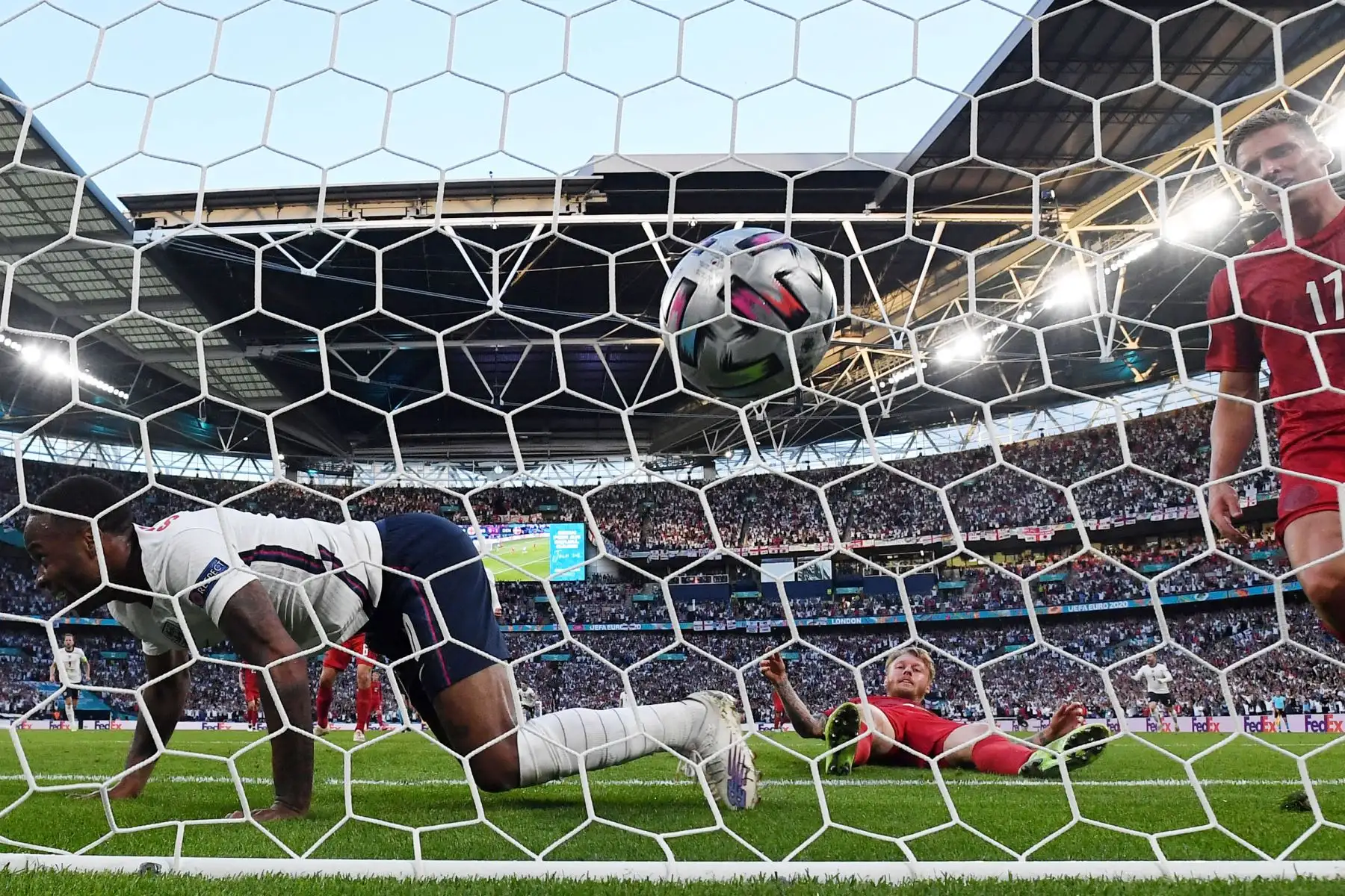 El delantero de Inglaterra Raheem Sterling  celebra después de que el defensor de Dinamarca Simon Kjaer  anotó un gol en propia meta durante el partido de fútbol semifinal de la UEFA EURO 2020 entre Inglaterra y Dinamarca en el estadio de Wembley en Londres. Foto: AFP