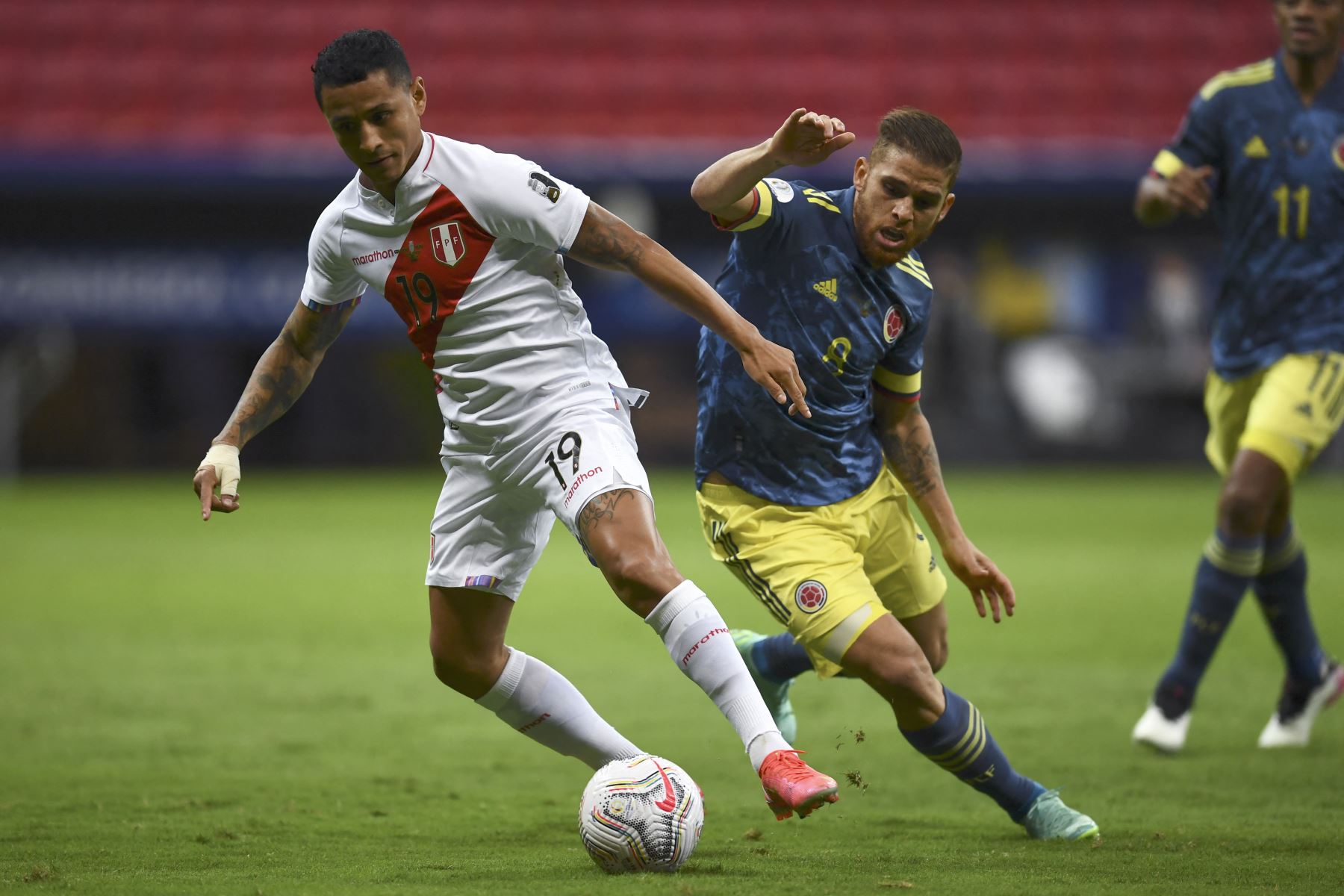 El peruano Yoshimar Yotun y el colombiano Gustavo Cuellar compiten por el balón durante el partido por el tercer puesto de la Copa América 2021, en el estadio Mane Garrincha de Brasilia. Foto: AFP