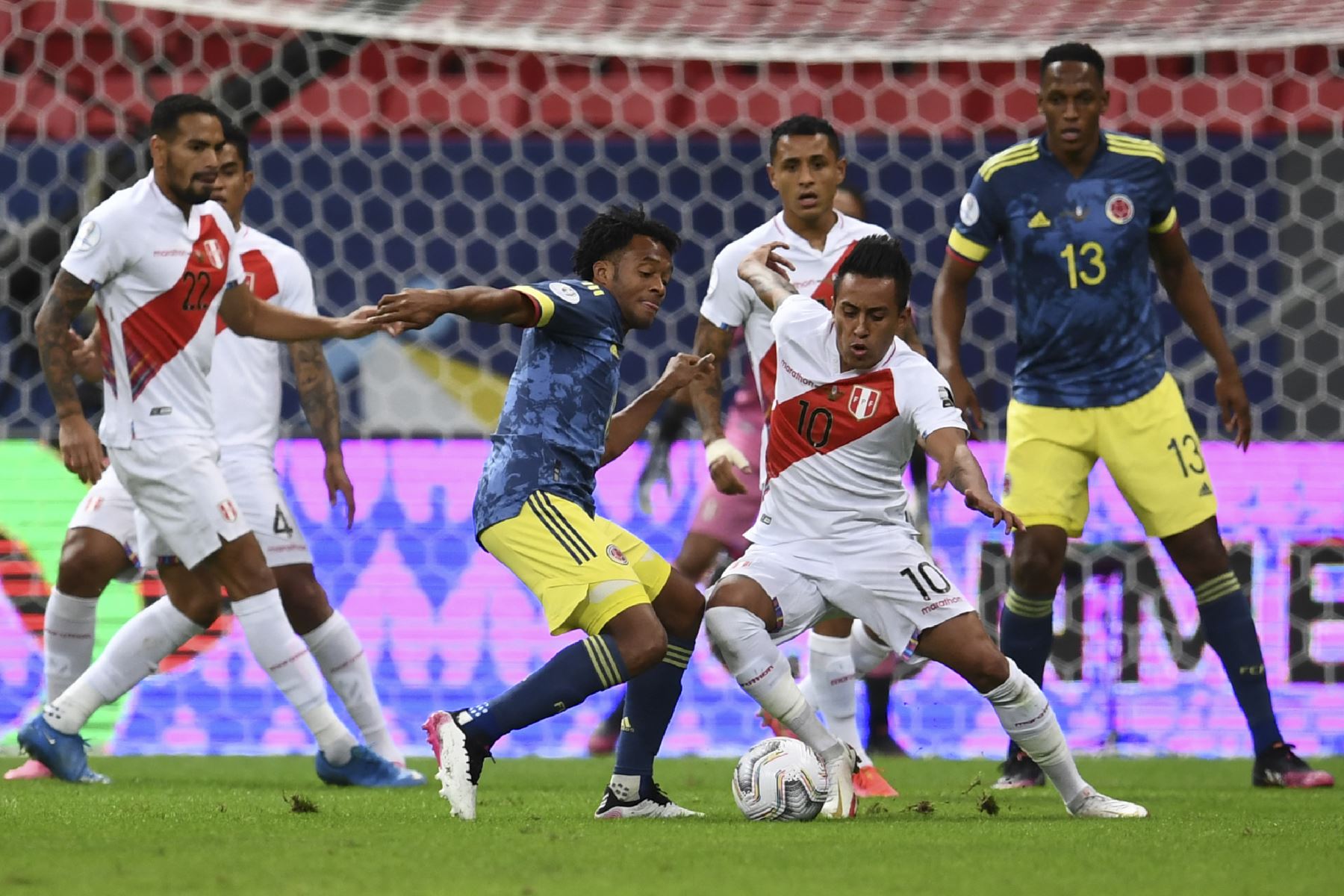 El colombiano Juan Cuadrado y el peruano Christian Cueva compiten por el balón durante el partido por el tercer puesto de la Copa América 2021, en el estadio Mane Garrincha de Brasilia. Foto: AFP