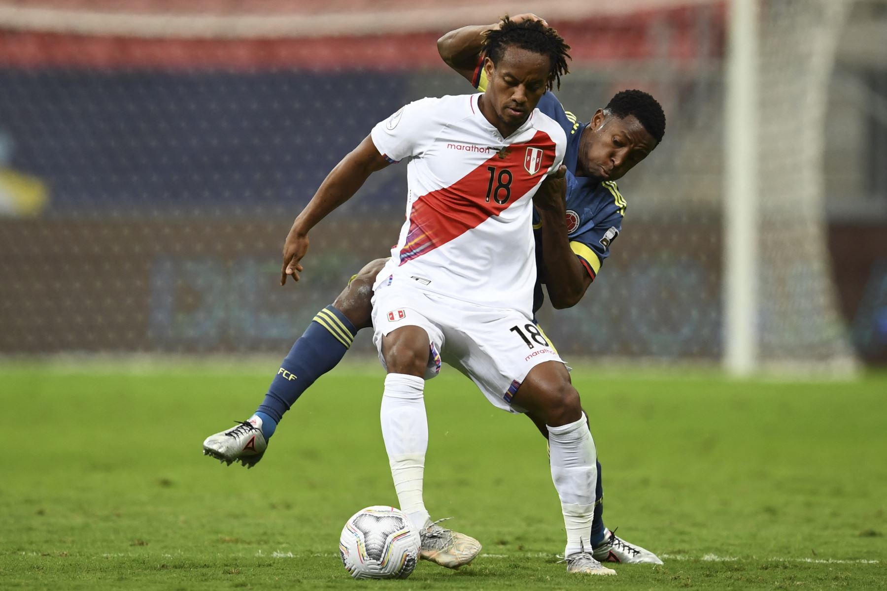 El peruano Andre Carrillo y el colombiano Oscar Murillo compiten por el balón durante el partido por el tercer puesto de la Copa América 2021, en el estadio Mane Garrincha de Brasilia. Foto: AFP