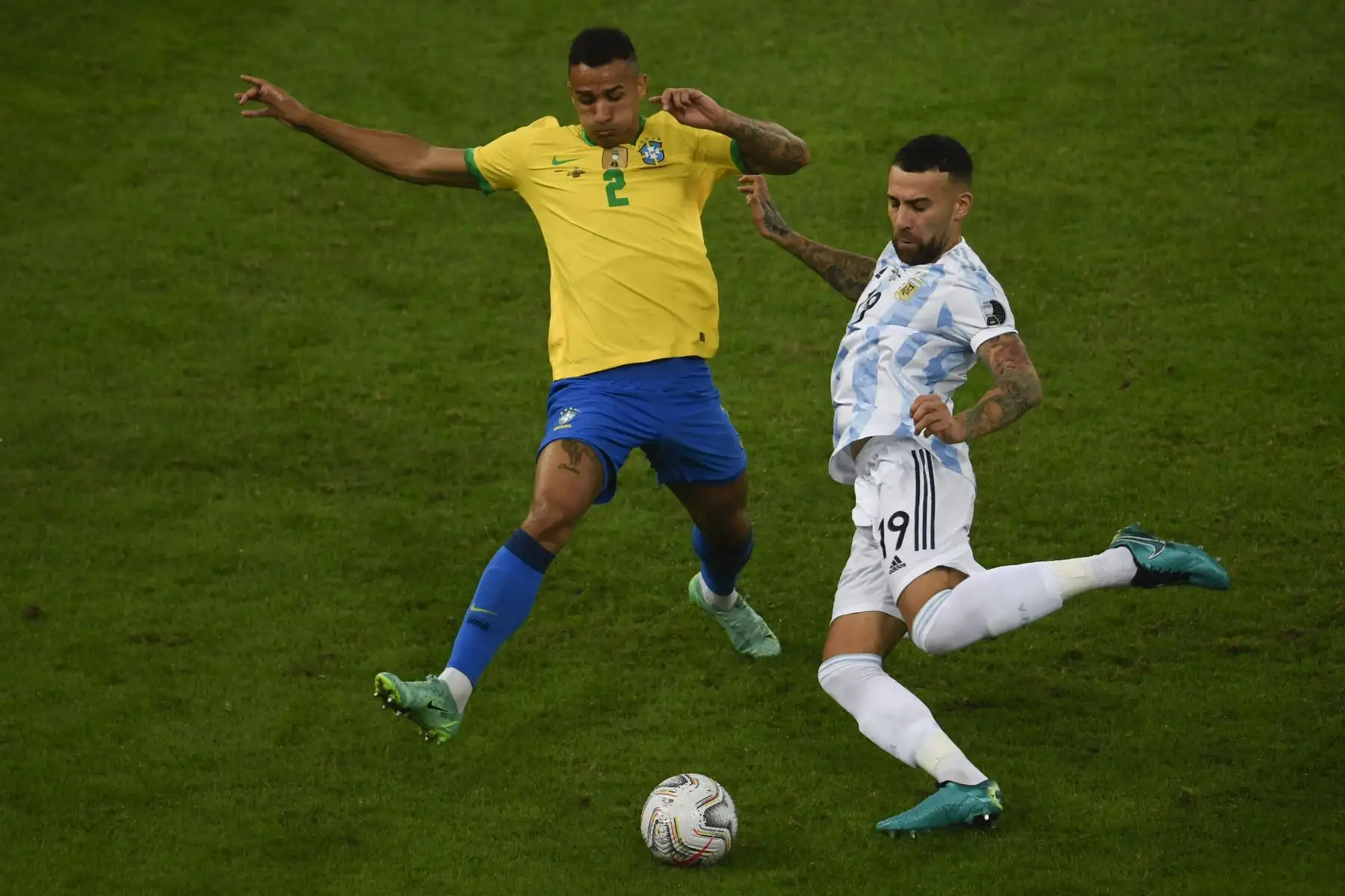 El brasileño Danilo (izq.) Y el argentino Nicolás Otamendi compiten por el balón durante la final del torneo de fútbol de la Copa América Conmebol 2021 en el Estadio Maracaná de Río de Janeiro, Brasil, el 10 de julio de 2021. Foto: AFP