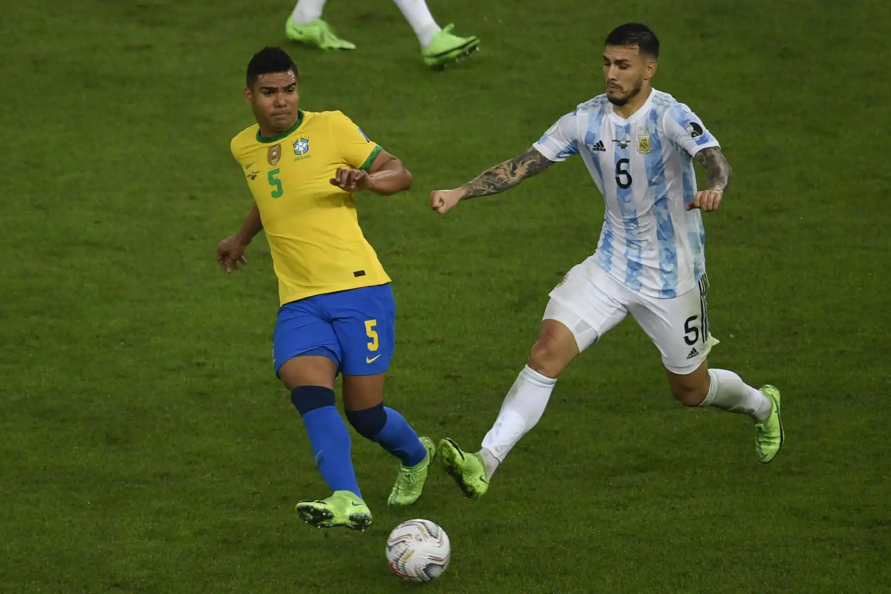 El brasileño Casemiro (izq.) Y el argentino Leandro Paredes compiten por el balón durante la final del torneo de fútbol de la Copa América Conmebol 2021 en el Estadio Maracaná de Río de Janeiro, Brasil, el 10 de julio de 2021. Foto: AFP