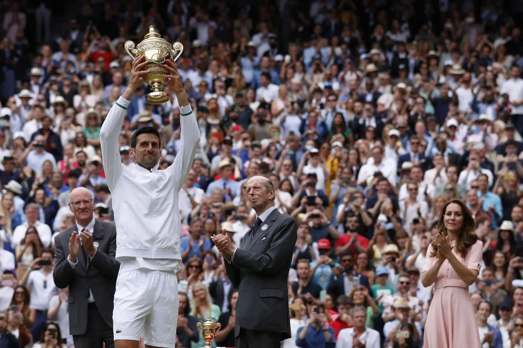 El serbio Novak Djokovic, con la británica Catherine , duquesa de Cambridge, sostiene el trofeo de ganador después de vencer al italiano Matteo Berrettini durante el partido final de individuales masculinos en el decimotercer día del Campeonato de Wimbledon 2021.
Foto: AFP