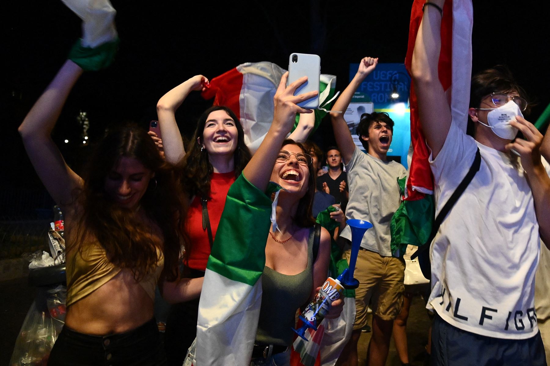Los seguidores de la selección italiana de fútbol celebran después de que Italia venciera a Inglaterra por 3-2 en la tanda de penaltis para ganar el partido de fútbol final de la UEFA EURO 2020, en la fanzone Fori Imperiali, en Roma el 11 de julio de 2021. Foto: AFP