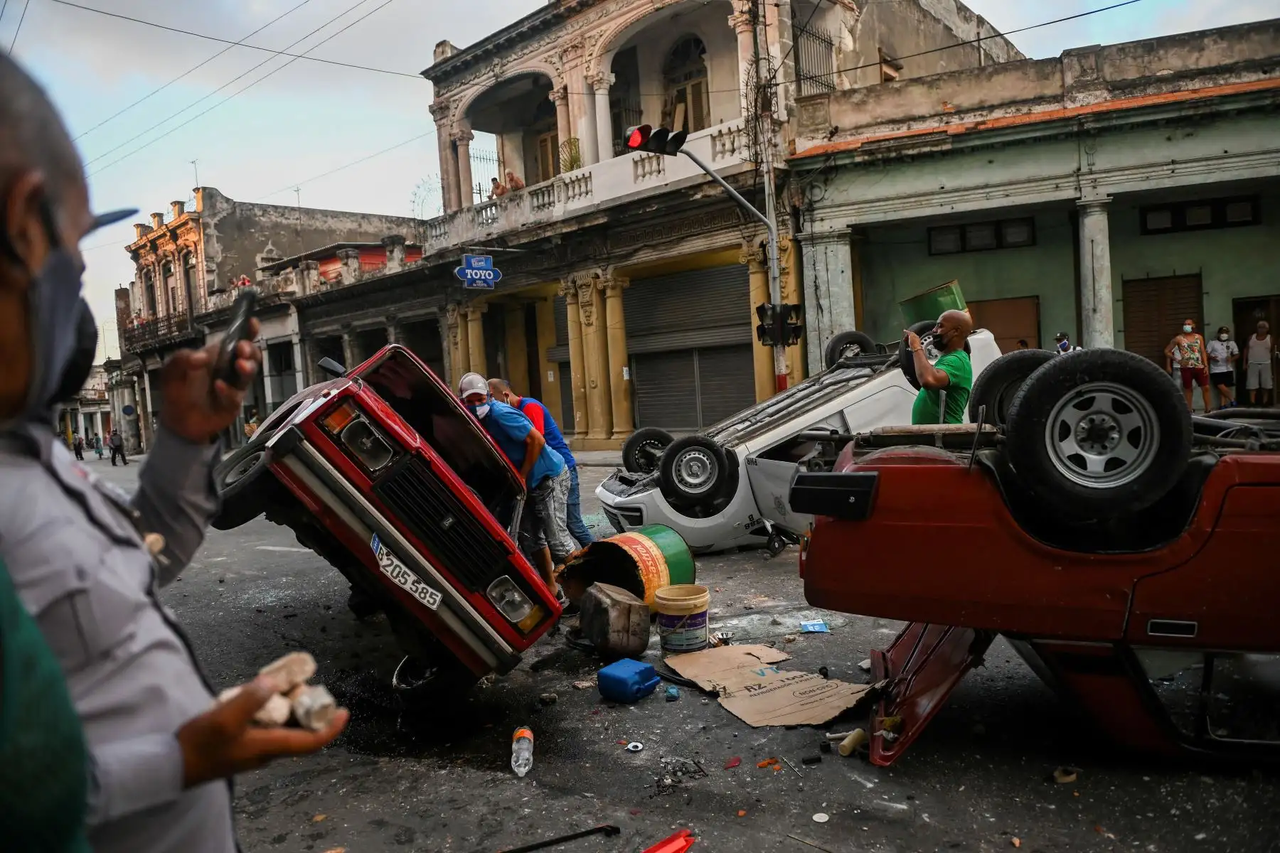 Los coches de la policía se ven volcados en la calle en el marco de una manifestación contra el presidente cubano Miguel Díaz-Canel en La Habana. Foto: AFP
