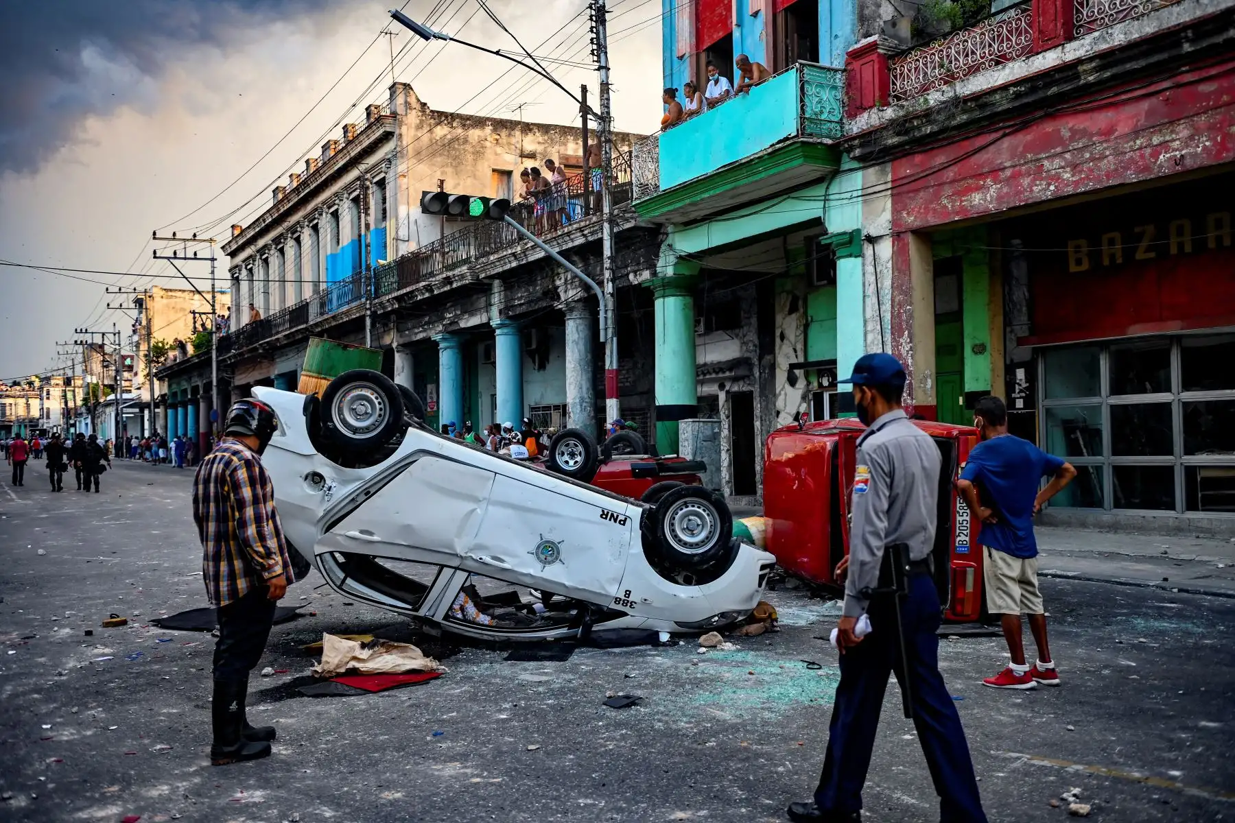 Los coches de la policía se ven volcados en la calle en el marco de una manifestación contra el presidente cubano Miguel Díaz-Canel en La Habana. Foto: AFP