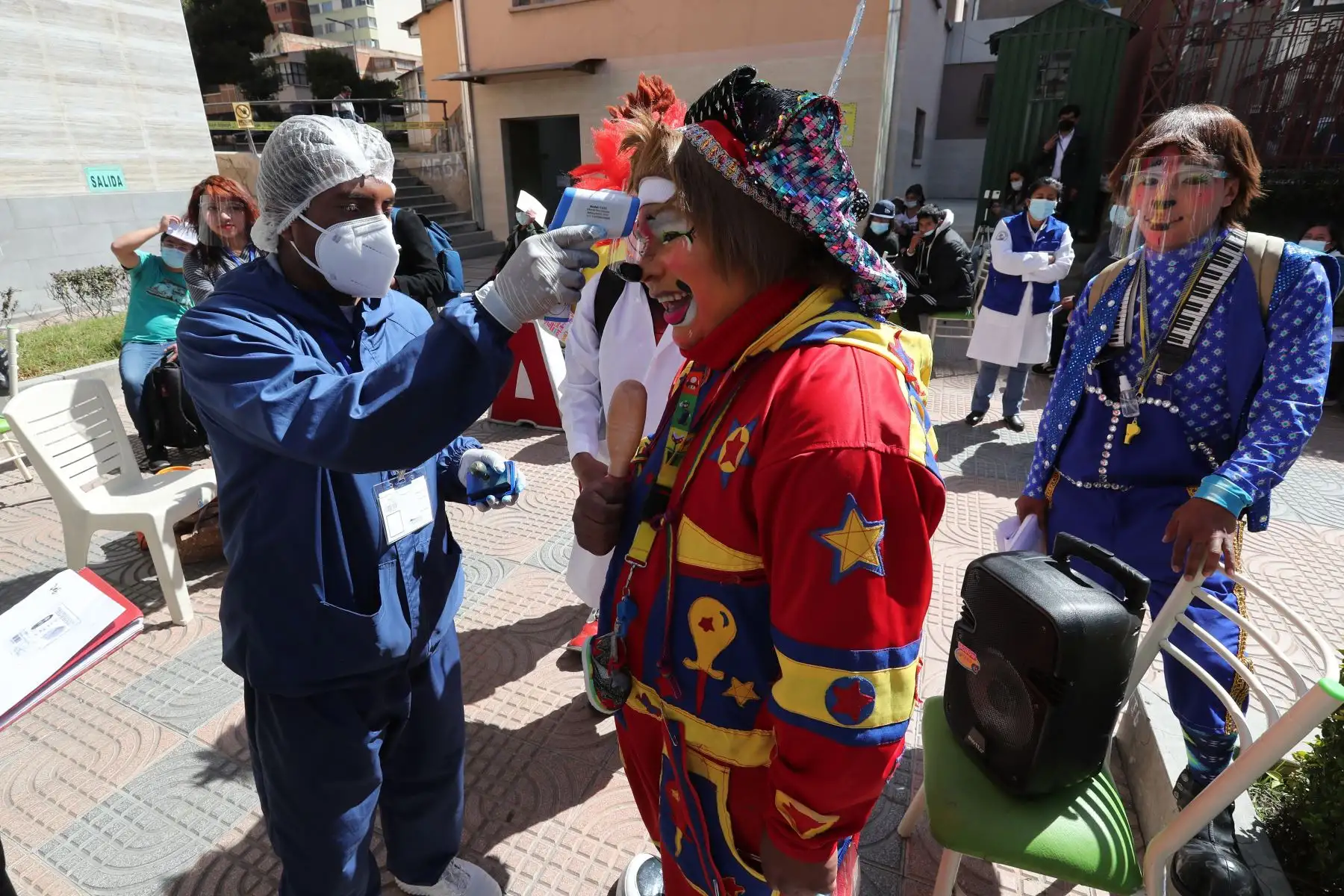 Personal de salud toma la temperatura a un payaso antes de que reciba la vacuna contra la covid-19, en La Paz, Bolivia. Foto: EFE