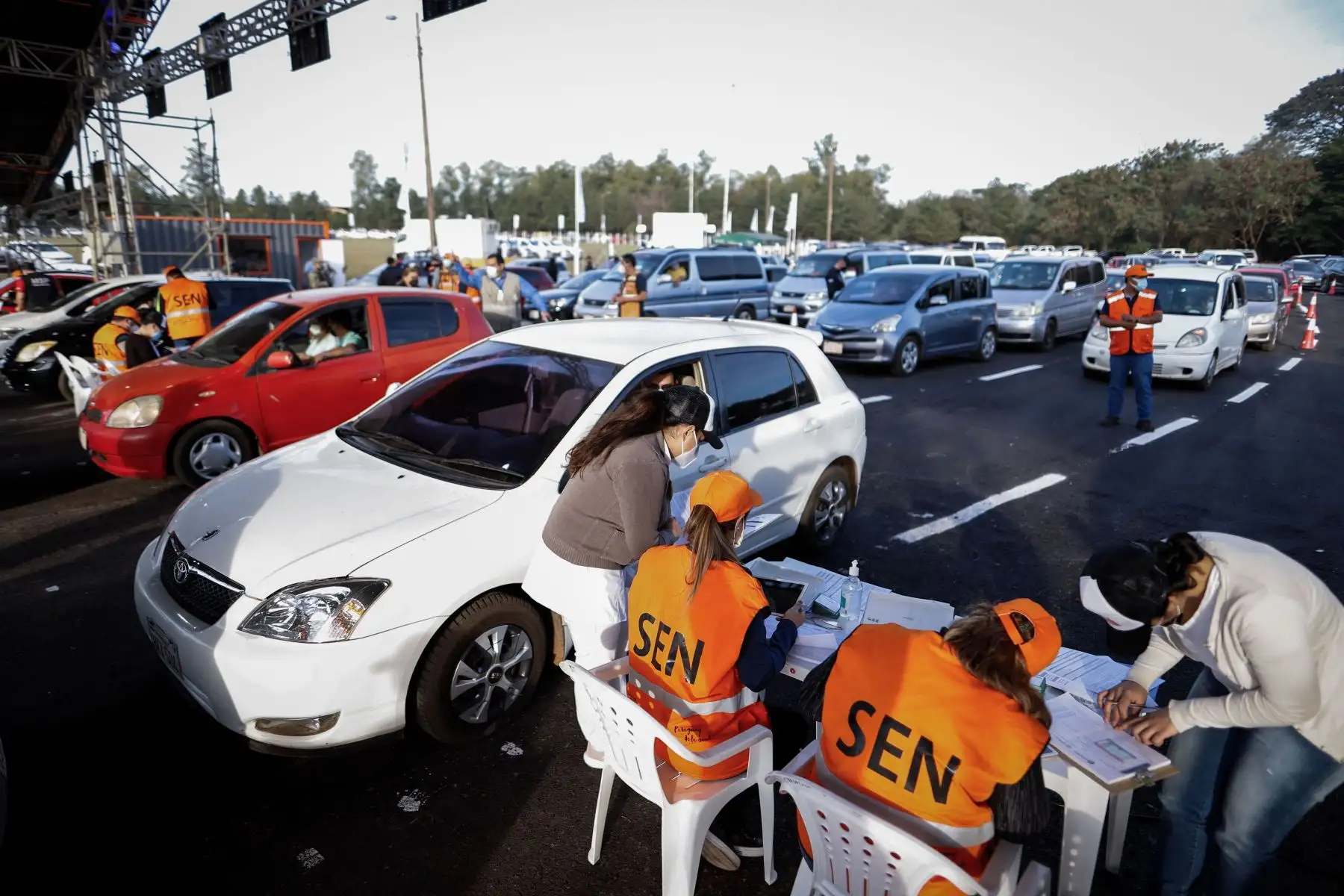Vehículos hacen fila para que sus ocupantes reciban la dosis de vacuna contra la covid-19, en Capiata, Paraguay. Foto: EFE