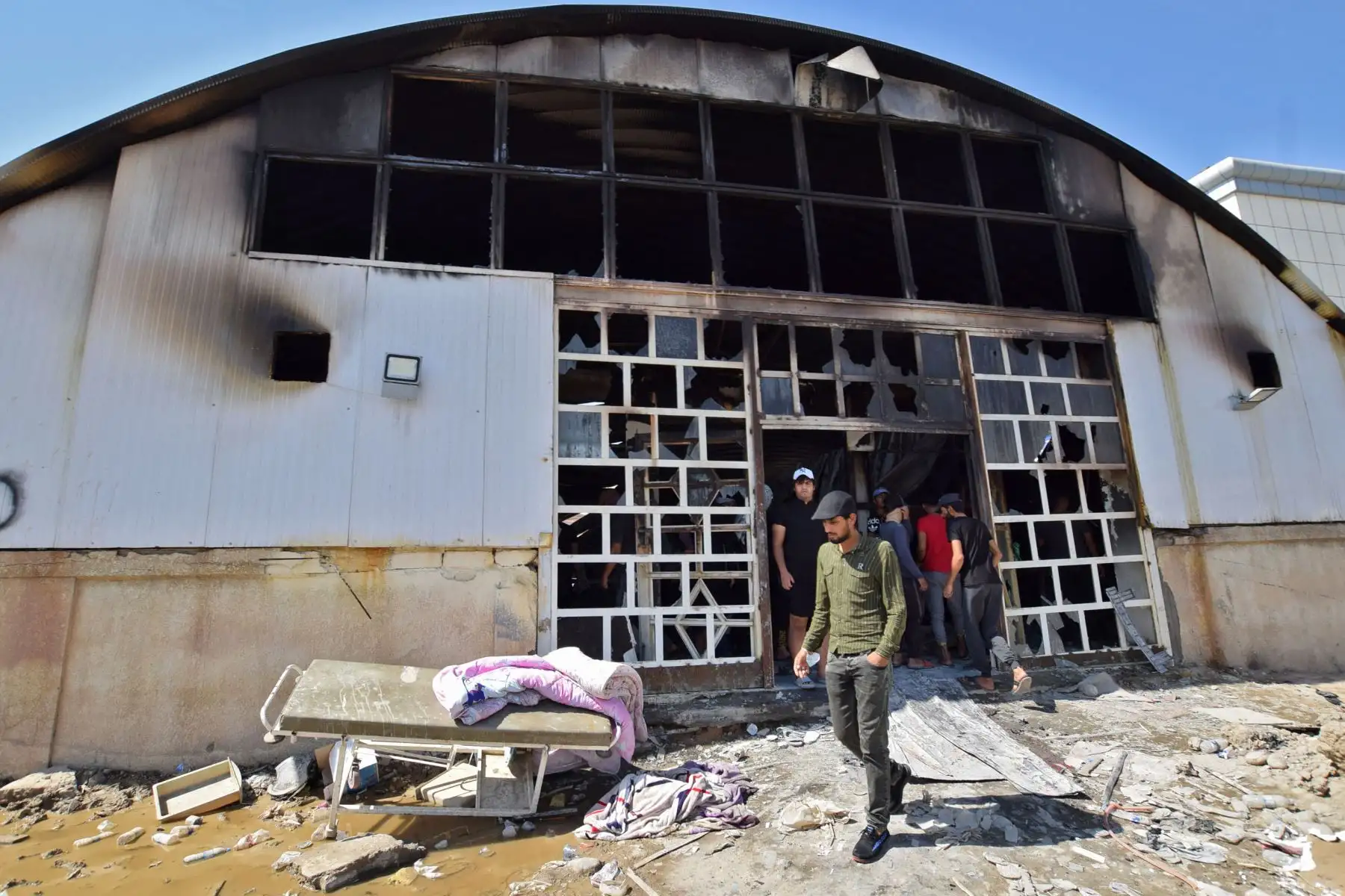 Las personas se reúnen en la sala de aislamiento del coronavirus devastada del hospital Al-Hussein después de un incendio masivo durante la noche, en la ciudad de Nasiriyah, en el sur de Irak.
Foto: AFP