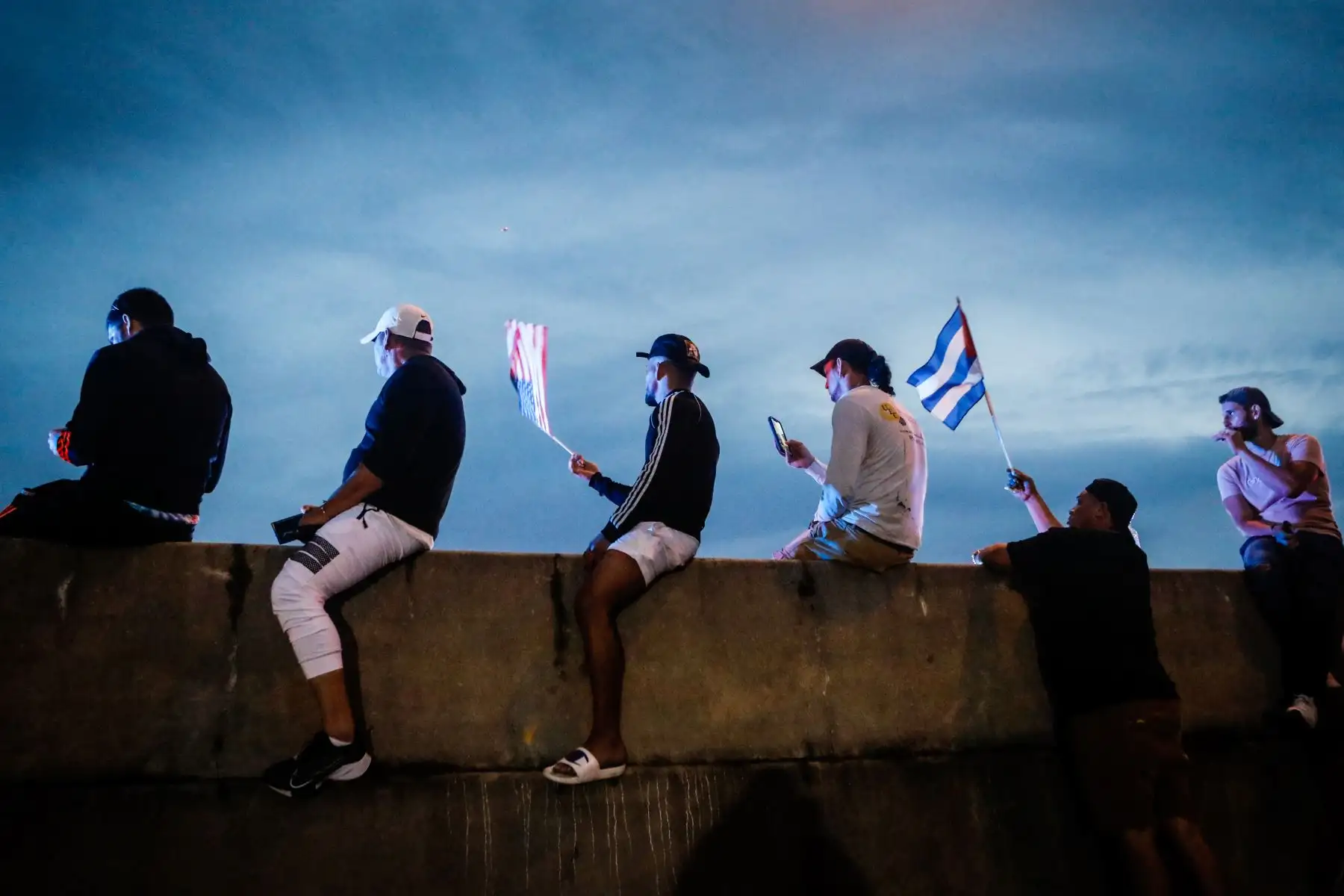 Personas sostienen banderas cubanas y estadounidenses mientras bloquean la Autopista Palmetto durante una protesta de apoyo a los cubanos que se manifiestan contra su gobierno, en Miami. Foto: AFP