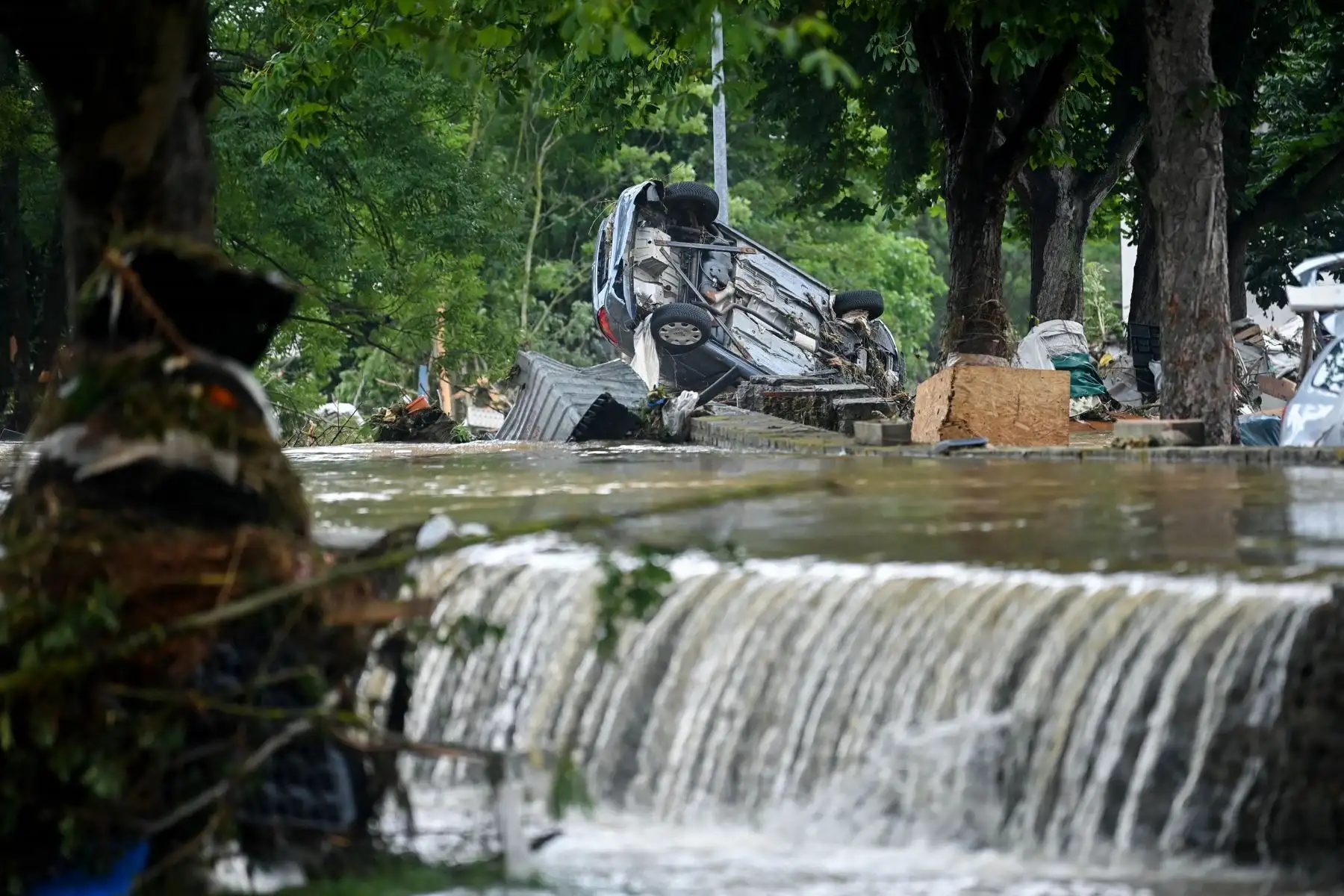 Un automóvil se encuentra boca abajo cerca del agua  en Iversheim, cerca de Bad Muenstereifel, en el oeste de Alemania. Foto: AFP