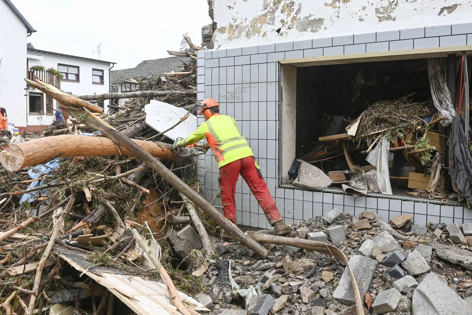 Un trabajador corta y quita árboles arrancados de raíz entre los escombros en medio de las casas destruidas después de que las inundaciones causaron daños importantes en Schuld, cerca de Bad Neuenahr-Ahrweiler, en el oeste de Alemania.
Foto: AFP