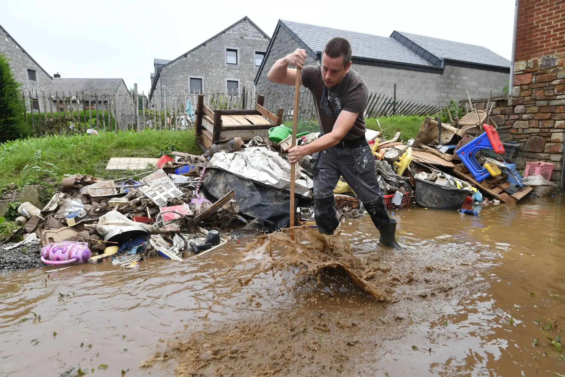 Un residente se encuentra en las aguas de la inundación mientras intenta aclararse luego de las fuertes lluvias e inundaciones en la ciudad de Rochefort, en Bélgica.
Foto: AFP