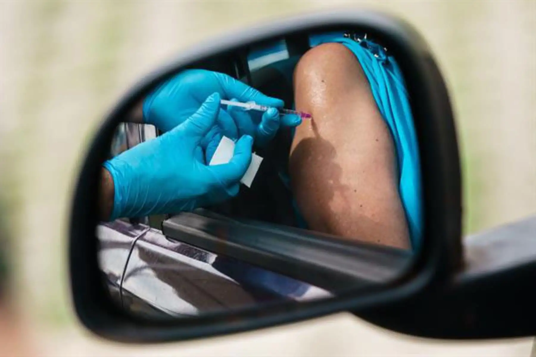 Se puede ver a una conductora de un automóvil en un espejo retrovisor mientras recibe una dosis de la vacuna contra el coronavirus en un estacionamiento en Berlín, Alemania.
Foto: AFP