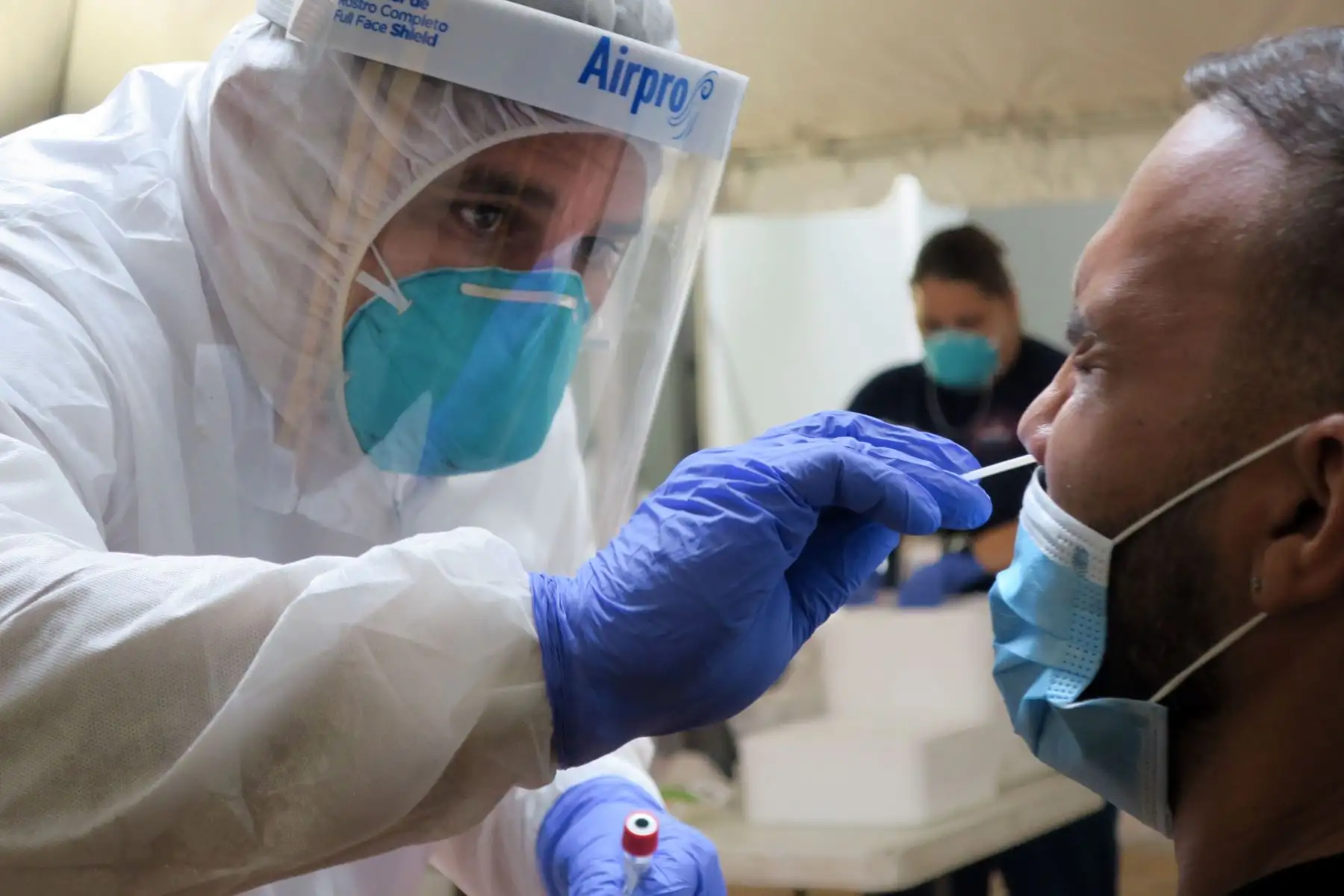 Un técnico de laboratorio inserta un hisopo en la nariz de un residente para la prueba del coronavirus en San Juan de Puerto Rico.
Foto: EFE