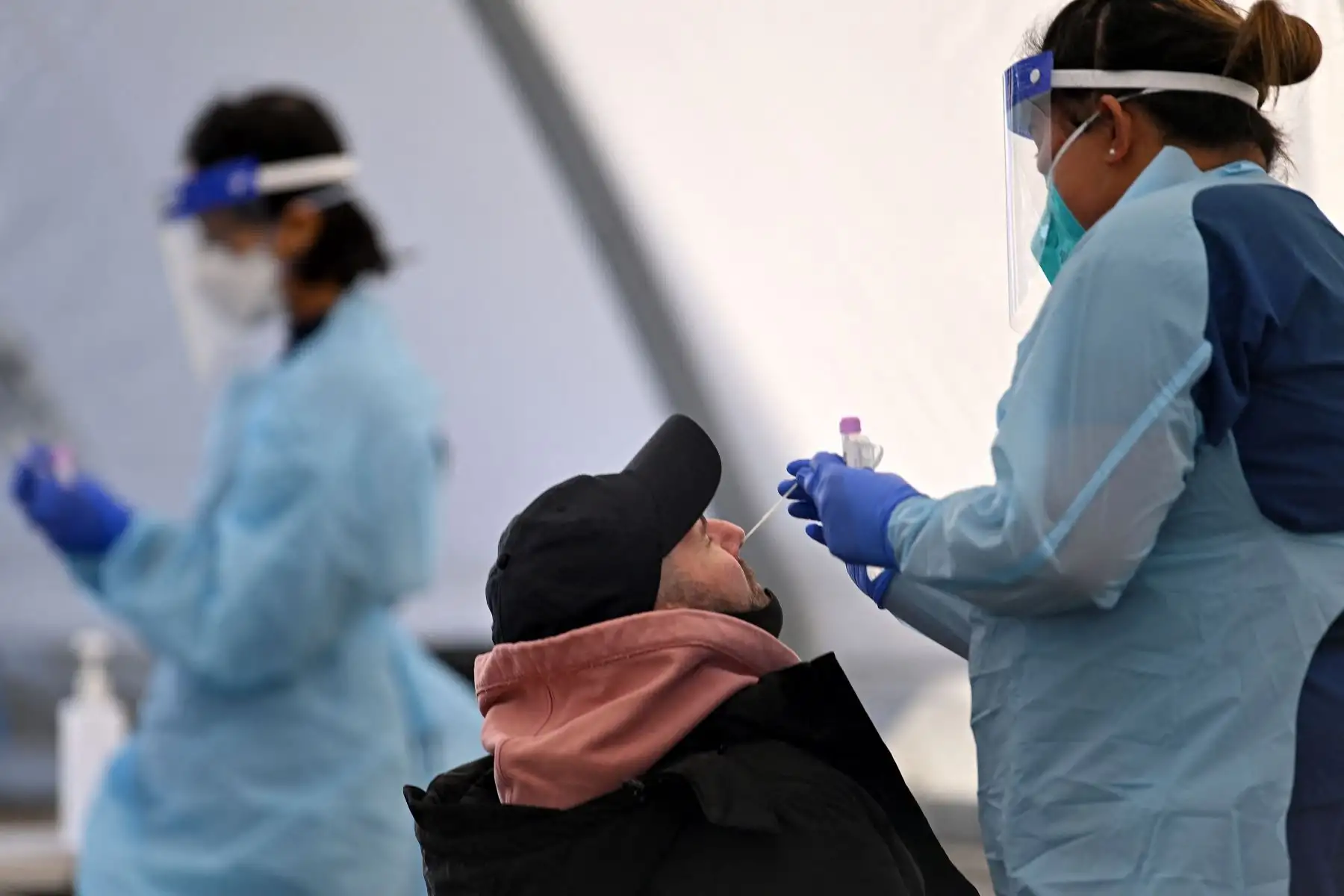 Un trabajador de la salud recolecta muestras de hisopos de un residente en una clínica de pruebas Covid-19 en Sydney.
Foto: AFP