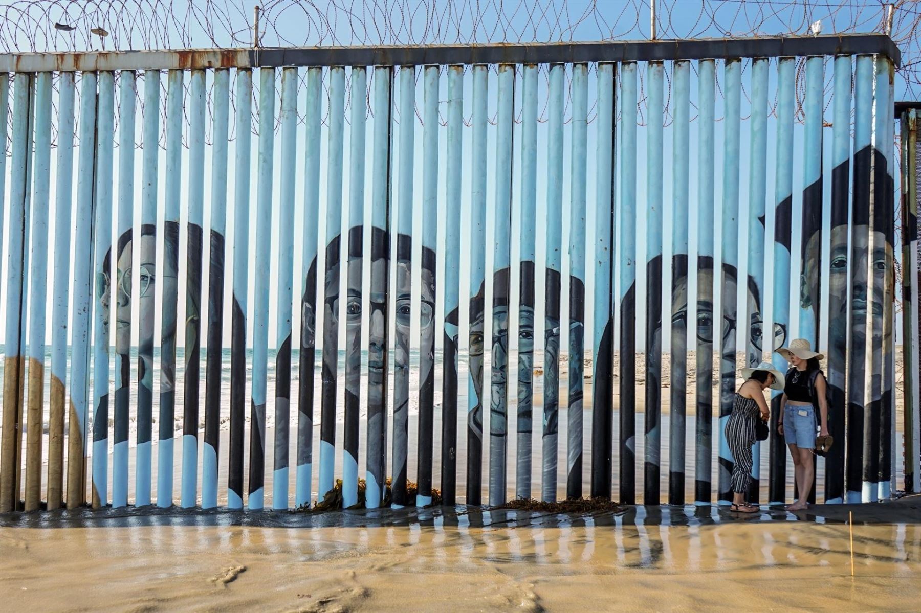 Rostros de los deportados se plasman en el muro entre México y EE. UU.