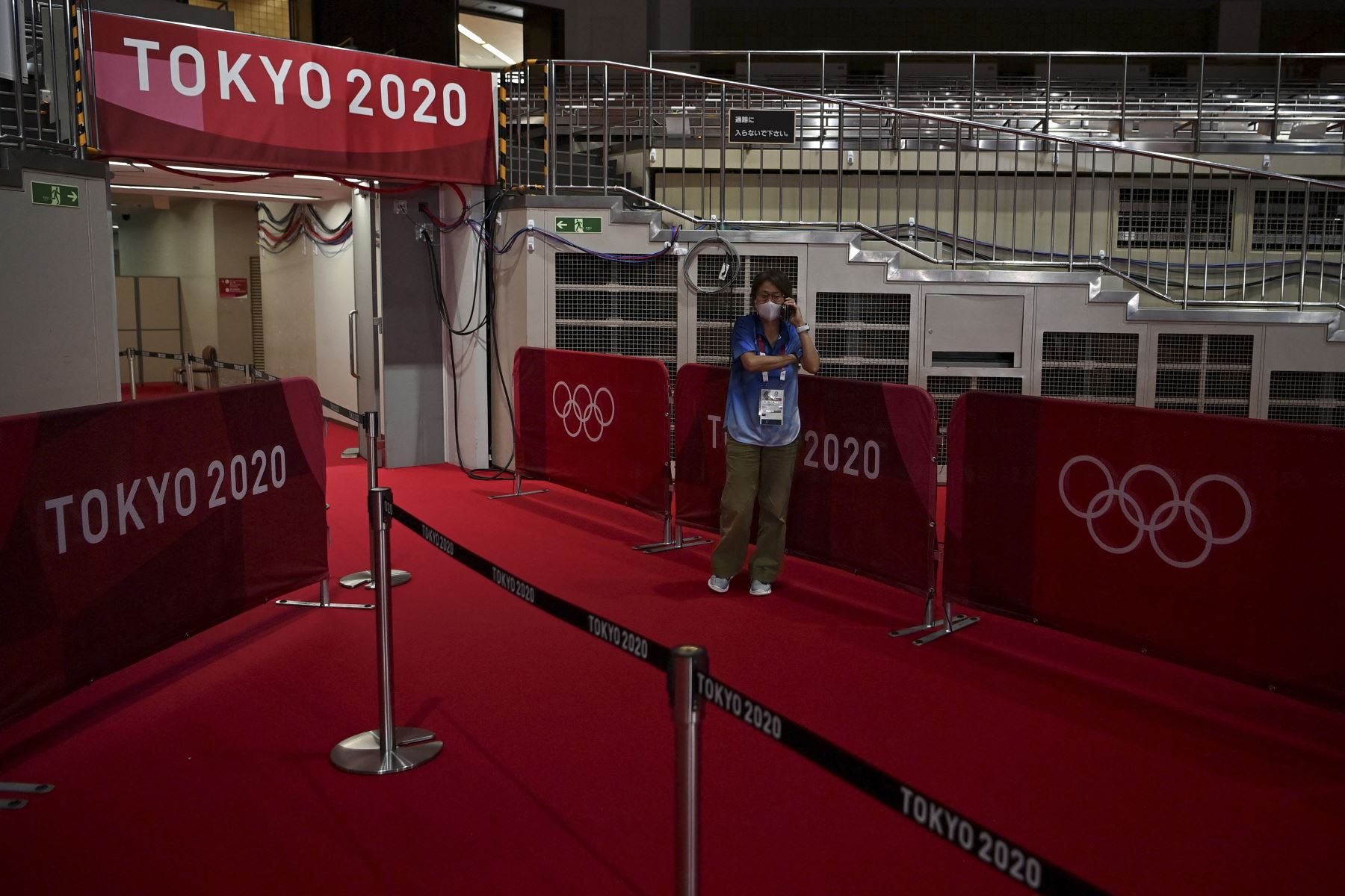 Un trabajador telefonea dentro del Kokugikan Arena en Tokio, antes del inicio de los Juegos Olímpicos de Tokio 2020. Foto: AFP