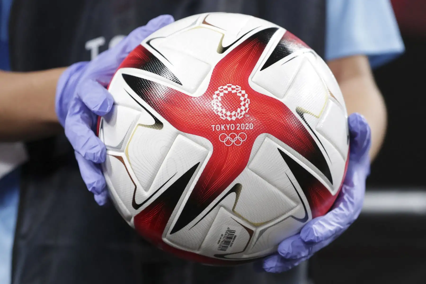 Una persona sostiene el balón de fútbol oficial antes del partido de fútbol de primera ronda del grupo E femenino de los Juegos Olímpicos de Tokio 2020, entre Gran Bretaña y Chile. Foto: AFP