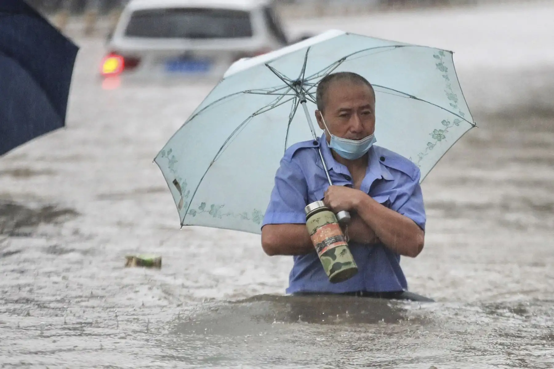 Un hombre trata de cruzar una calle completamente inundada en Zhengzhou, en la provincia de Henan, en China. Foto: AFP