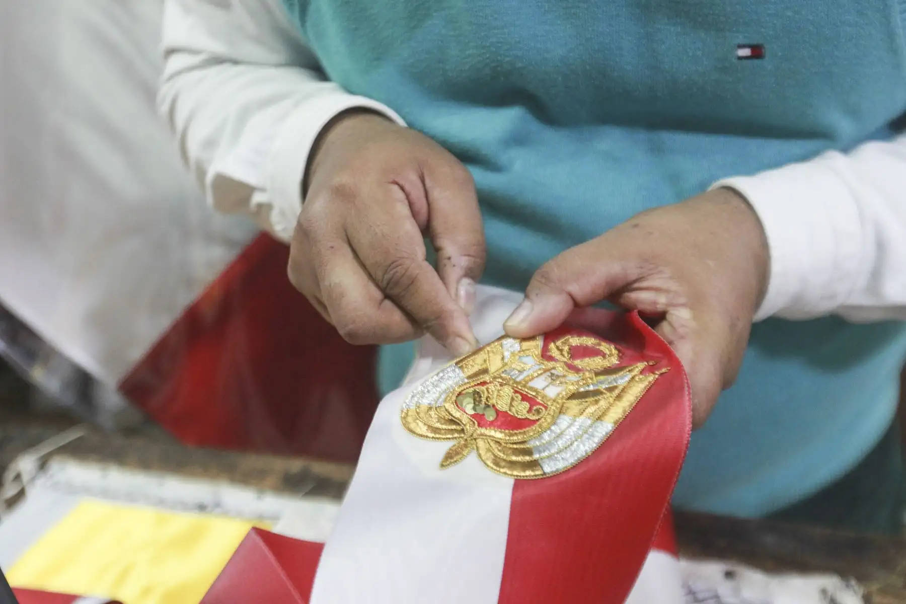 La banda presidencial no es cualquier accesorio; está confeccionada con raso muaré francés, una tela especial que se usa para los trajes del Papa y que utilizaron personajes de la historia, como Napoleón Bonaparte. Dante Grados, heredero de una tradición que inició su padre hace 74 años, explica que la tela es una tafeta muy delicada, que manda a traer con amigos para cumplir su tarea. Foto: ANDINA/Jhony Laurente