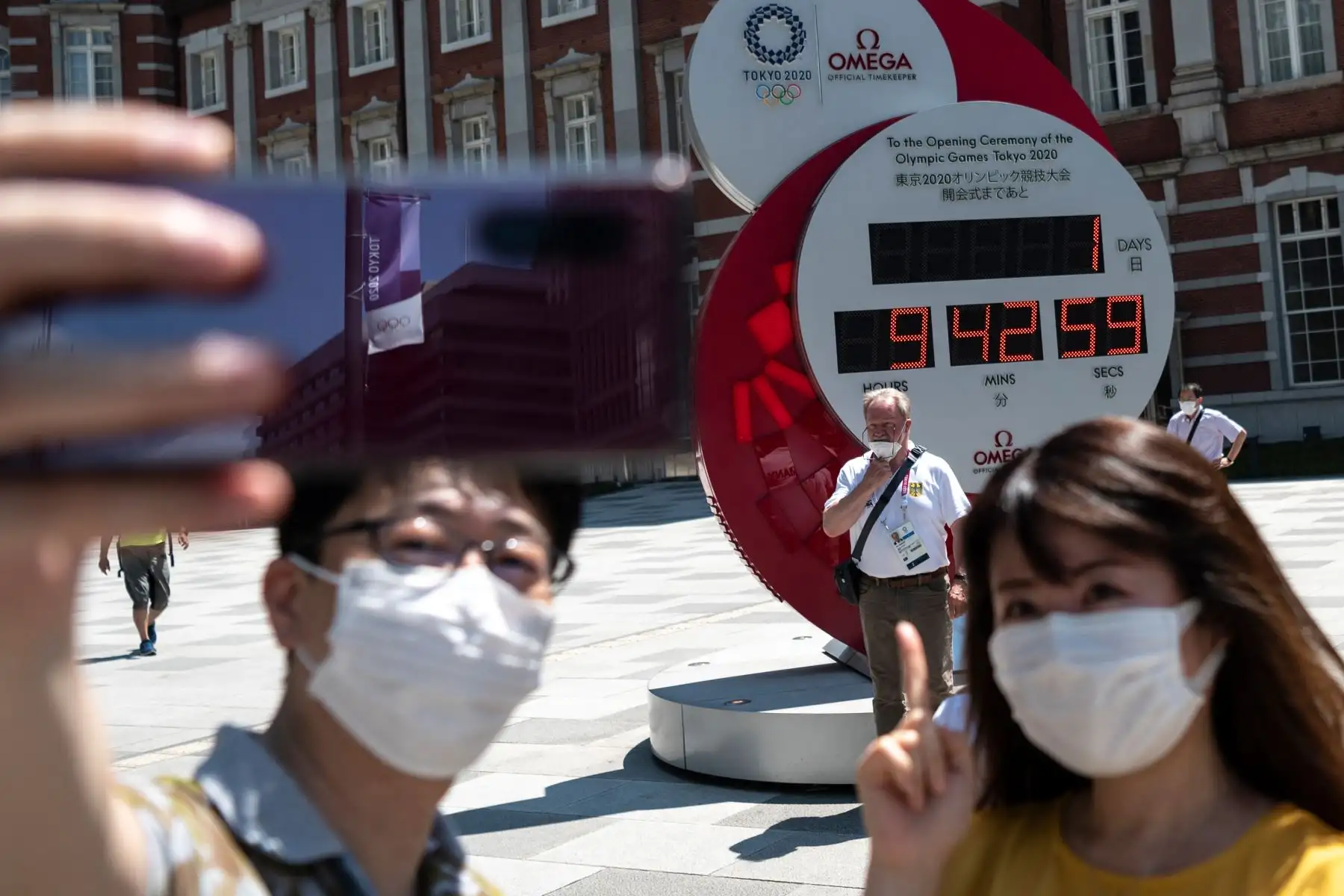 La gente toma fotografías del reloj de cuenta regresiva que indica 1 día y 9 horas antes del inicio de la ceremonia de apertura de los Juegos Olímpicos de Tokio 2020, en las afueras de la estación de Tokio. Foto: AFP
