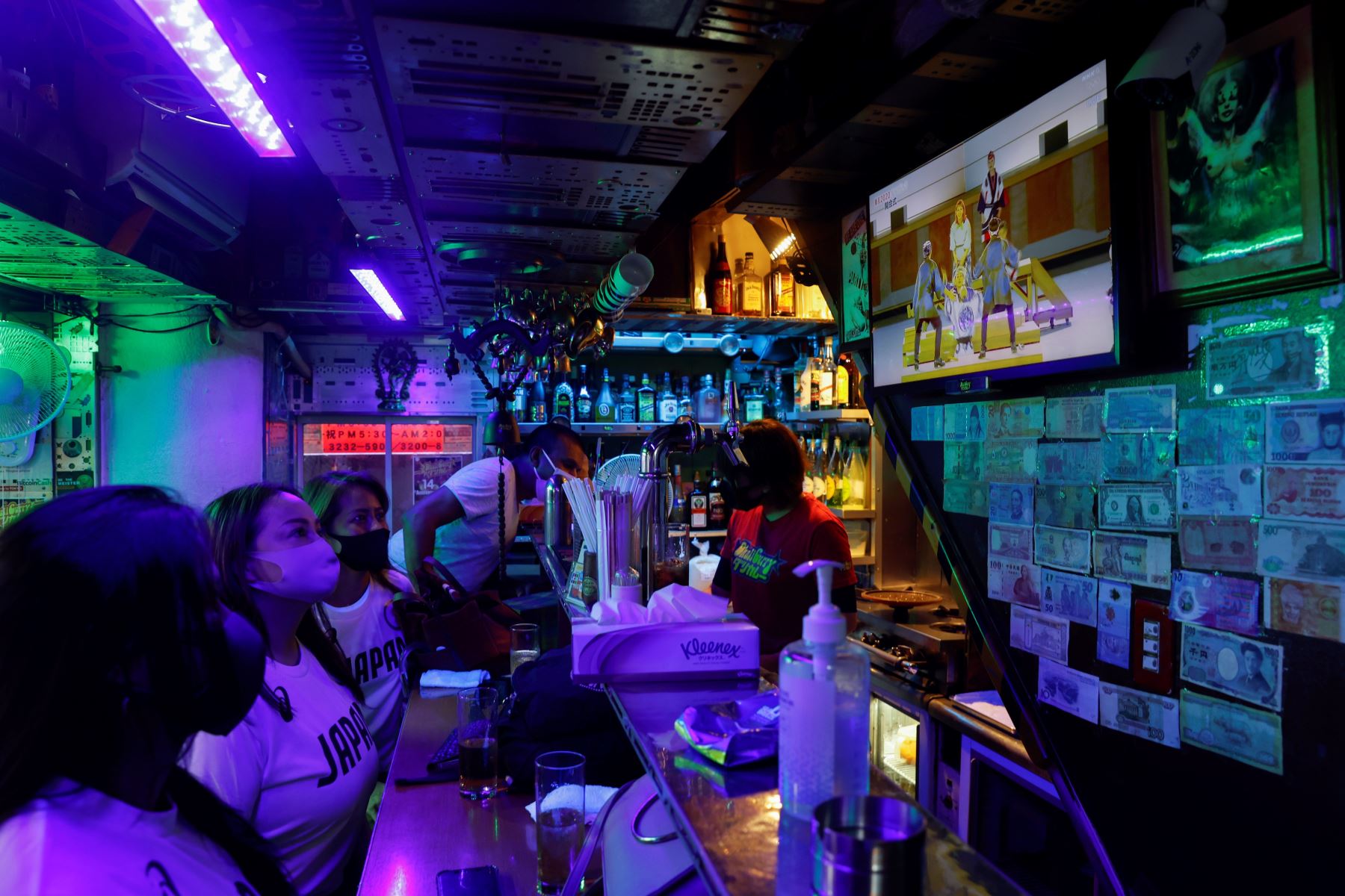 Clientes de un bar siguen por televisión la ceremonia inaugural de los Juegos Olímpicos de Tokio 2020. Foto: EFE