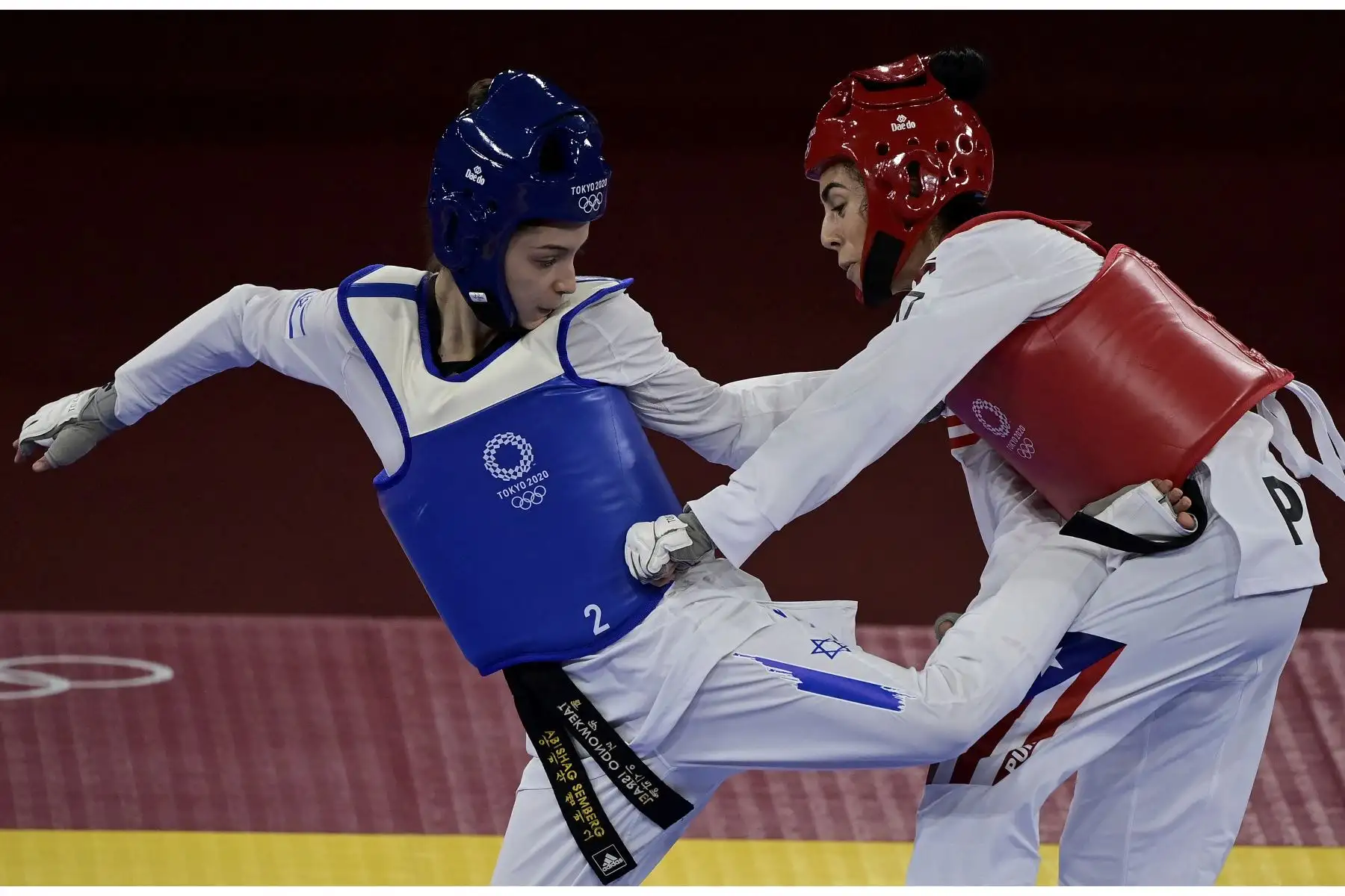 La israelí Abishag Semberg y la puertorriqueña Victoria Stambaugh compiten en la ronda eliminatoria femenina de taekwondo de -49 kg durante los Juegos Olímpicos de Tokio 2020, en el Makuhari Messe Hall, en Tokio. Foto: AFP