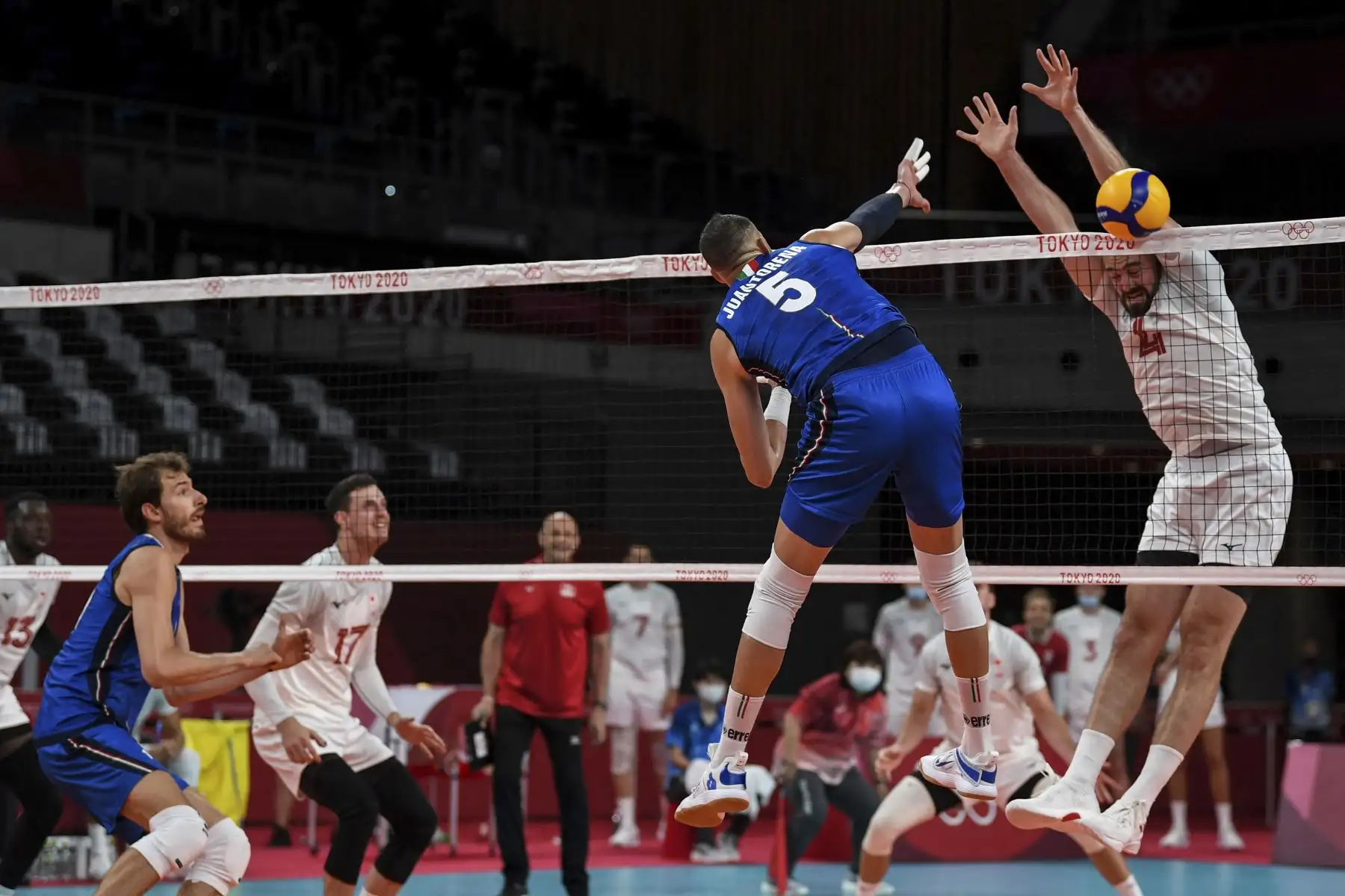 El italiano Osmany Juantorena remata la pelota mientras el canadiense Nicholas Hoag lo bloquea durante partido de voleibol de la ronda preliminar masculina A entre Italia y Canadá por los Juegos Olímpicos de Tokio 2020. Foto: AFP