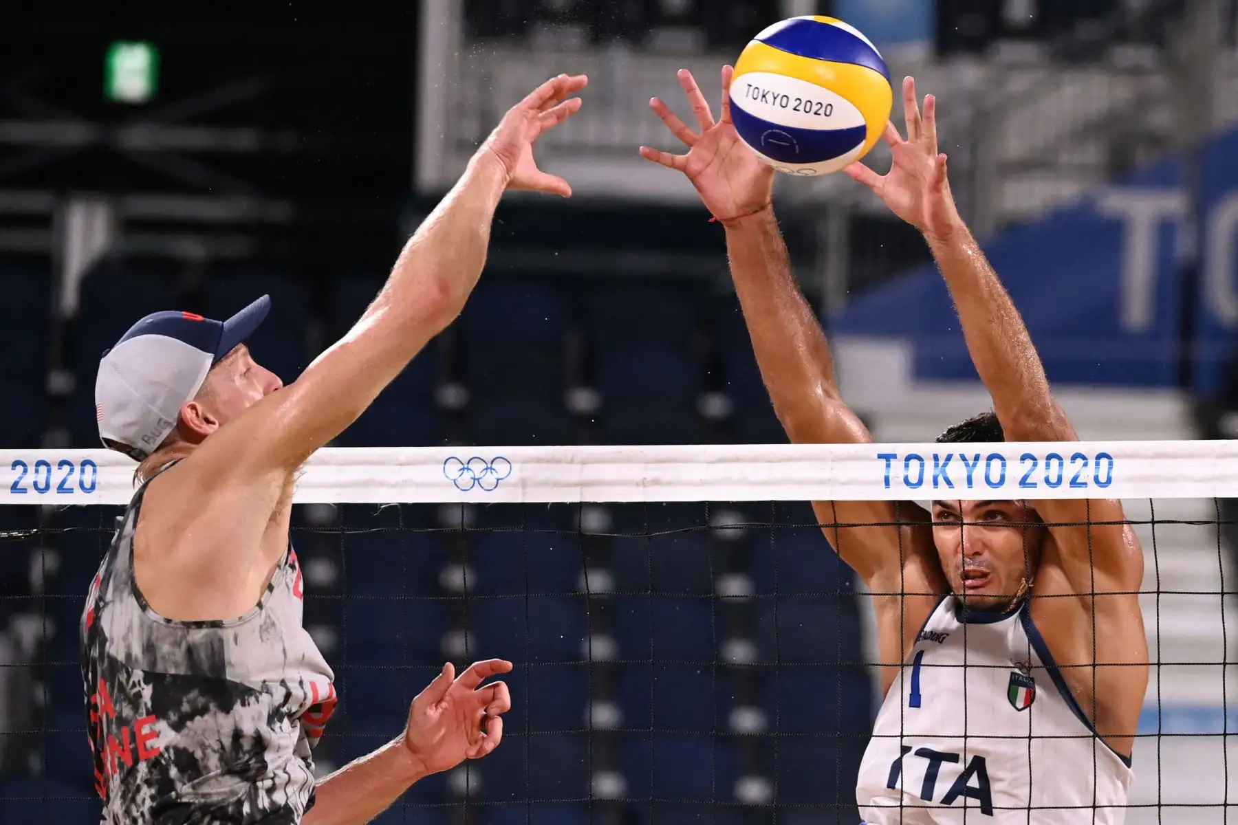 El italiano Enrico Rossi  bloquea un disparo del estadounidense Tri Bourne en el partido preliminar del grupo C de voleibol de playa masculino entre Estados Unidos e Italia durante los Juegos Olímpicos de Tokio 2020.
Foto: AFP