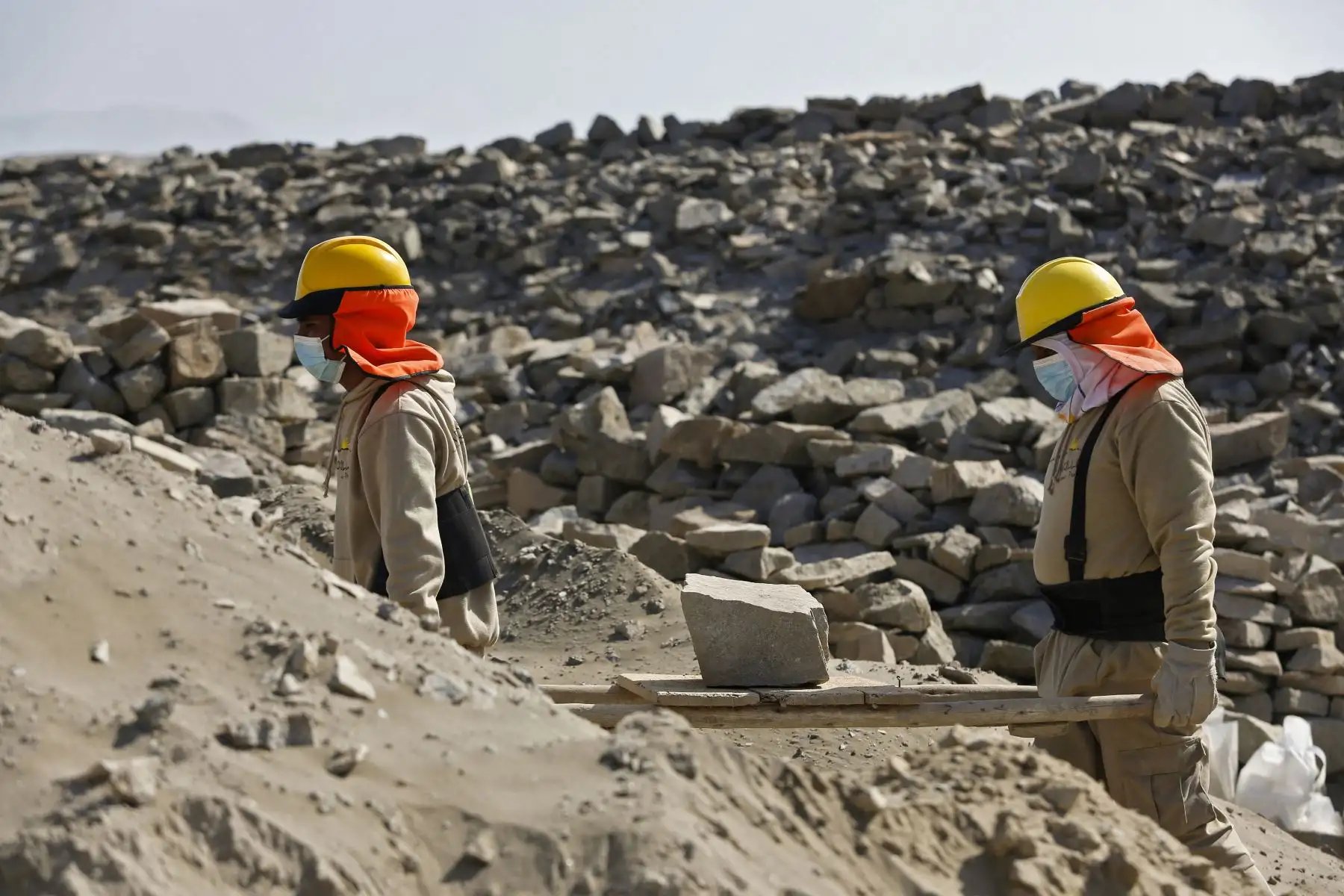 Los trabajadores transportan material durante las obras de recuperación en el Observatorio Solar Chankillo cerca de Casma, Perú. Chankillo, el observatorio solar más antiguo de América entre 500 y 200 a. C., es un complejo de piedra que incluye un templo, plaza y 13 torres alineadas de norte a sur a lo largo de la cima de una colina. 
Foto: AFP