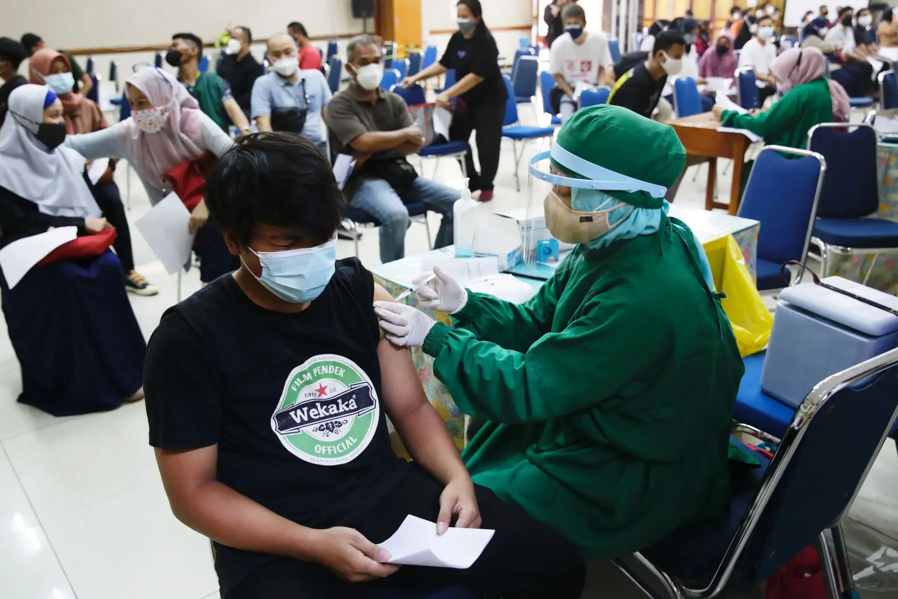 Un estudiante de escuela recibe una dosis de la vacuna COVID-19 durante una campaña masiva en un edificio escolar en Yakarta, Indonesia. Foto: EFE