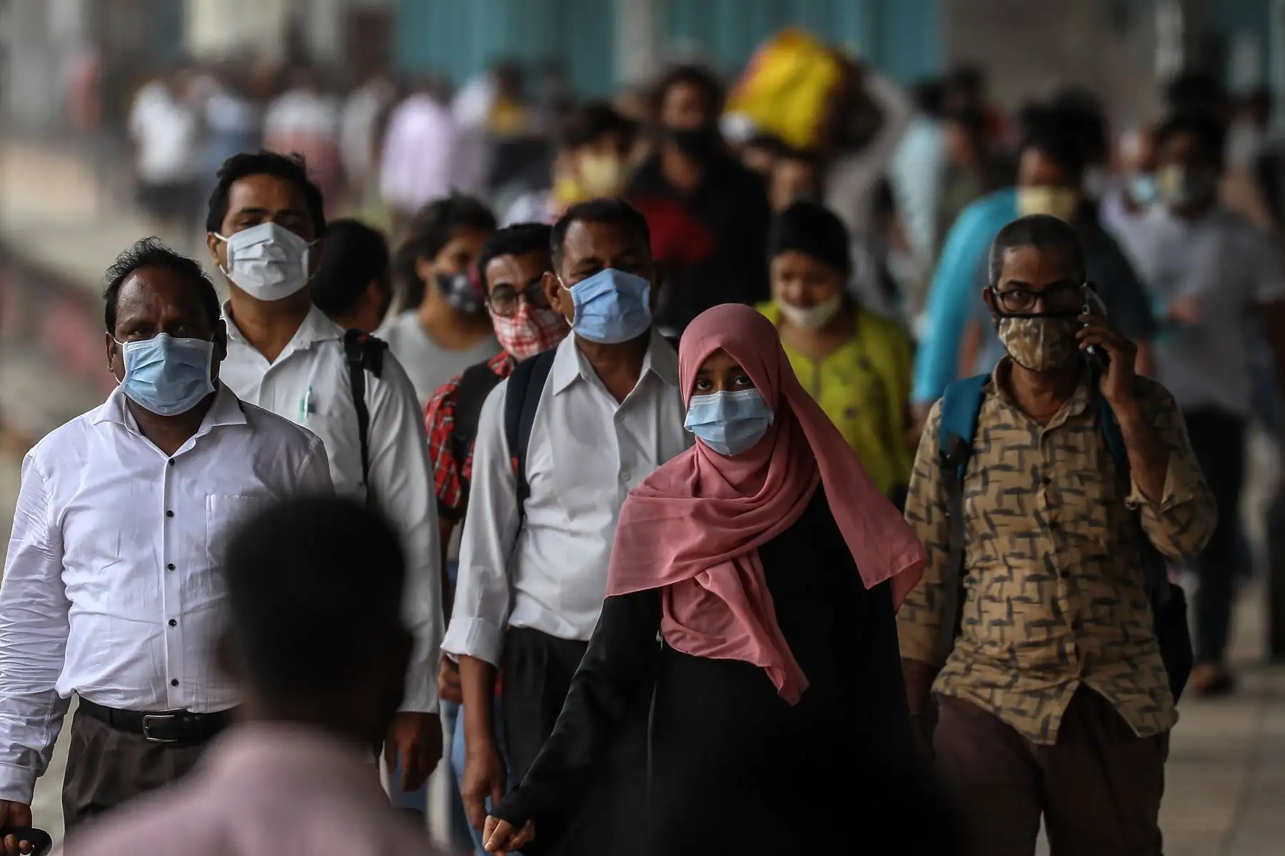Pasajeros indios con máscaras faciales hacen cola para hacerse la prueba de detección covid-19 después de llegar desde otros estados de la India a Mumbai. Foto: EFE
