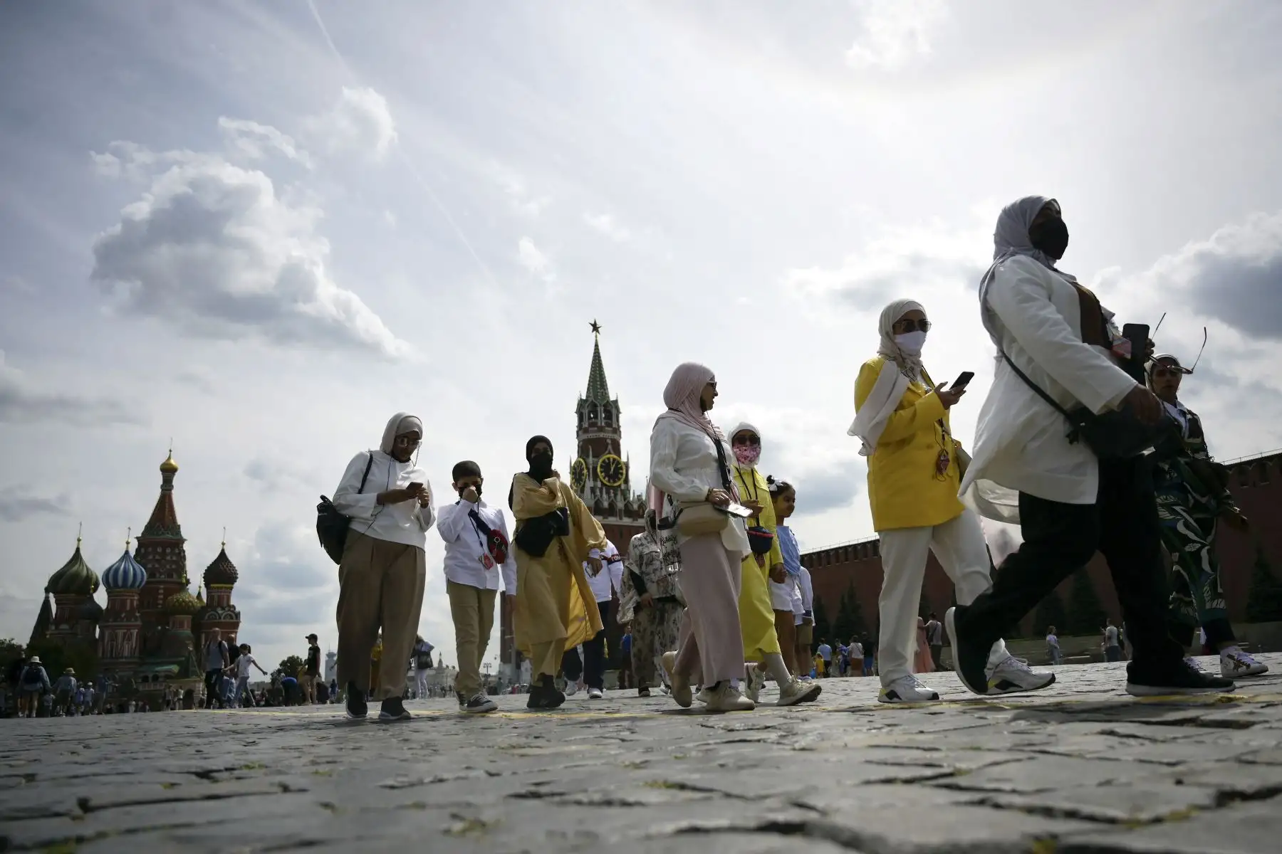 Turistas caminan con mascarillas para protegerse contra la covid-19 por la Plaza Roja en Moscú, Rusia. Foto: AFP