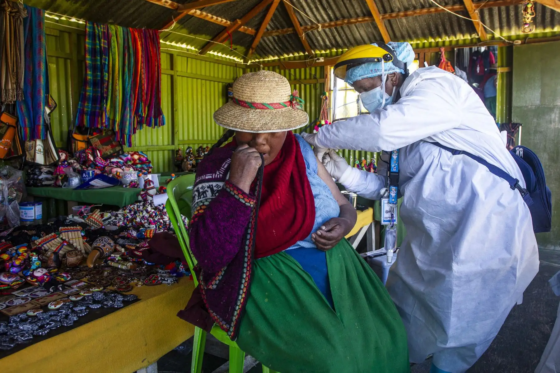 Un trabajador de salud inocula a una mujer con una dosis de la vacuna Sinopharm contra la covid-19, en las islas de los Uros, en el lago Titicaca, en Puno. Foto: AFP