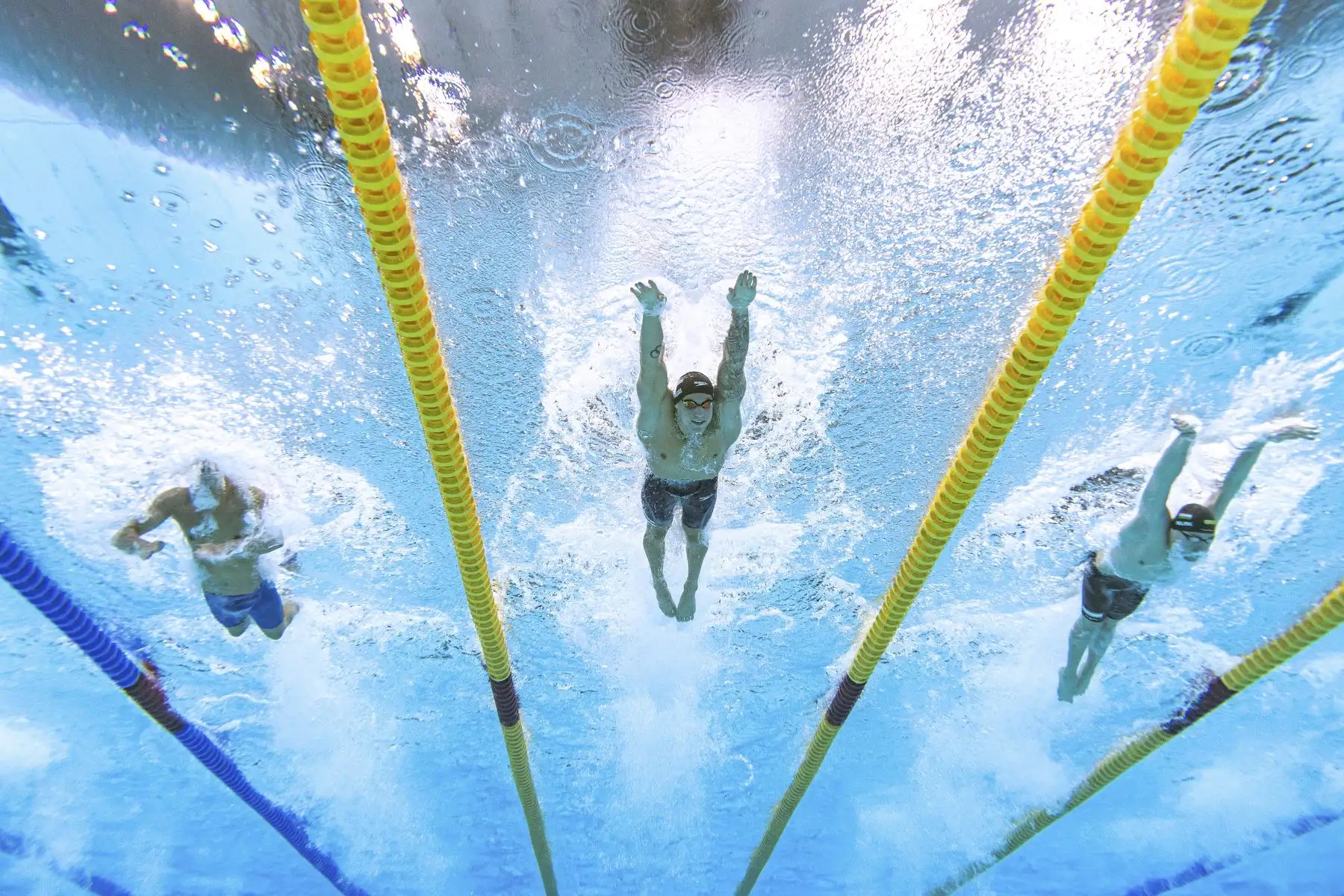 Una vista submarina muestra al húngaro Kristof Milak, el estadounidense Caeleb Dressel y el suizo Noe Ponti, mientras compiten en la final de natación estilo mariposa - 100 metros, durante los Juegos Olímpicos de Tokio 2020, en el Centro Acuático de Tokio. Foto: AFP
