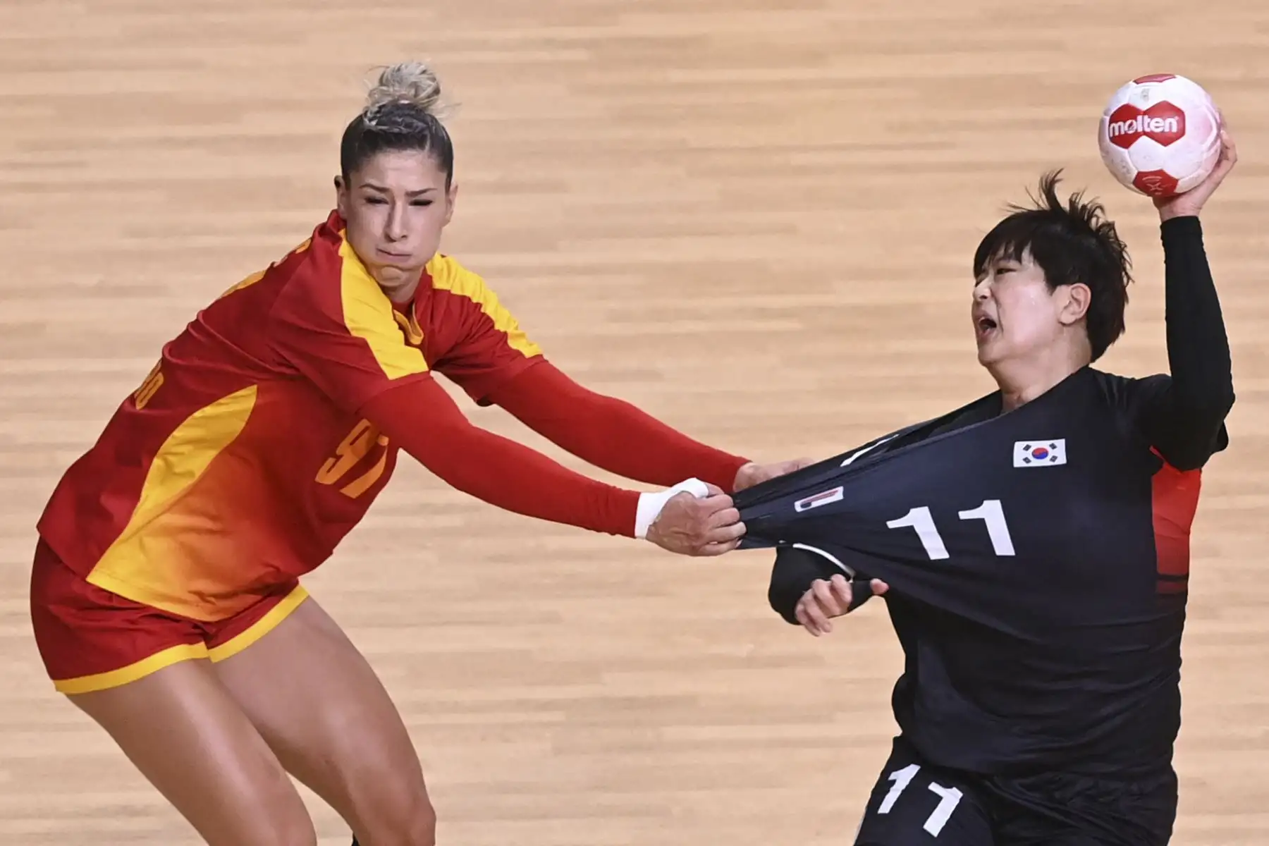 El pivote de Montenegro Nikolina Vukcevic desafía al lateral derecho de Corea del Sur Ryu Eun-hee durante el partido de balonmano del grupo A de los Juegos Olímpicos de Tokio 2020, en el Estadio Nacional Yoyogi. Foto: AFP