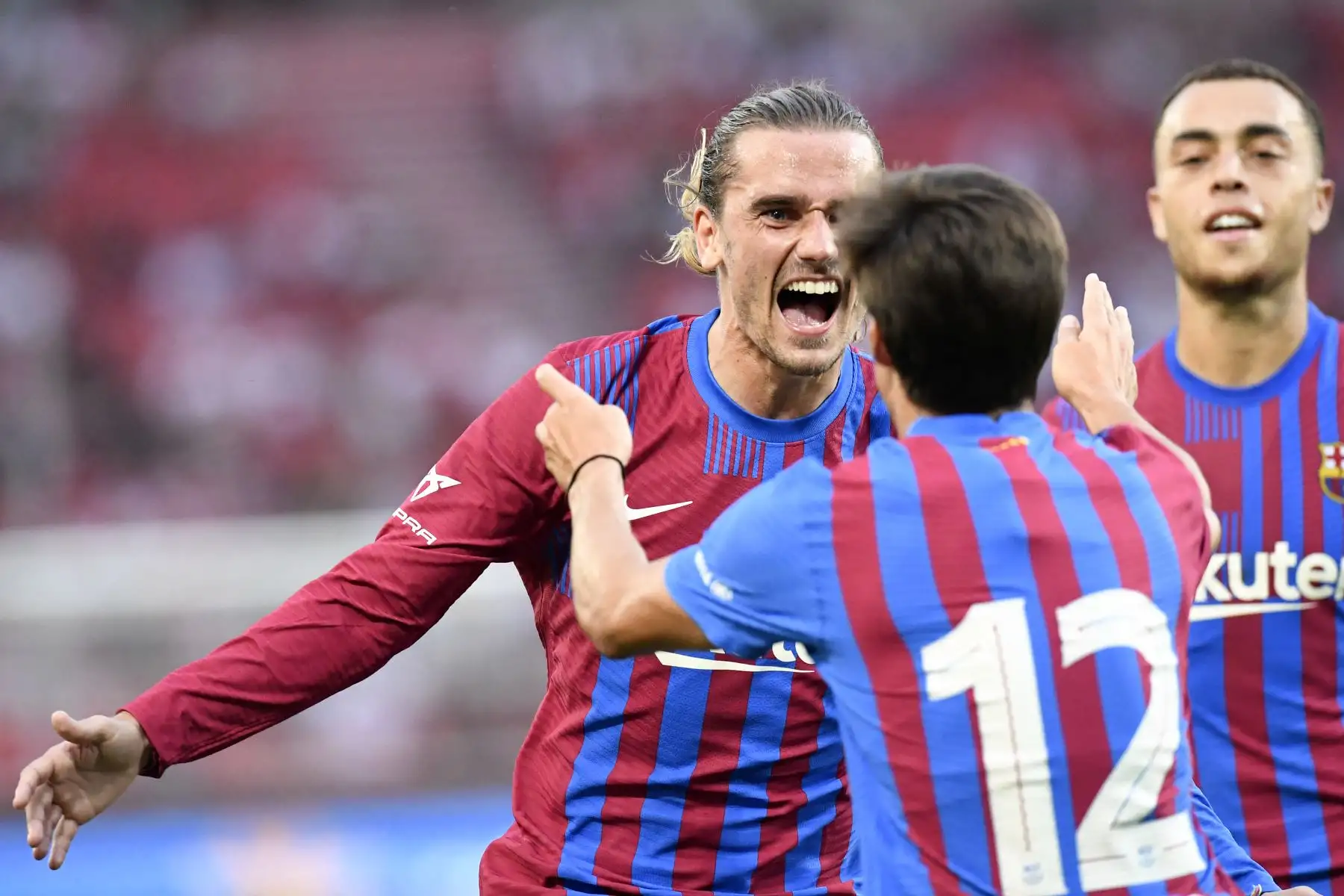 El delantero francés del Barcelona Antoine Griezmann felicita al centrocampista español Riqui Puig después que anote el 3-0 en partido amistoso, en el estadio Mercedes Benz Arena de Berlín, Alemania. Foto: AFP