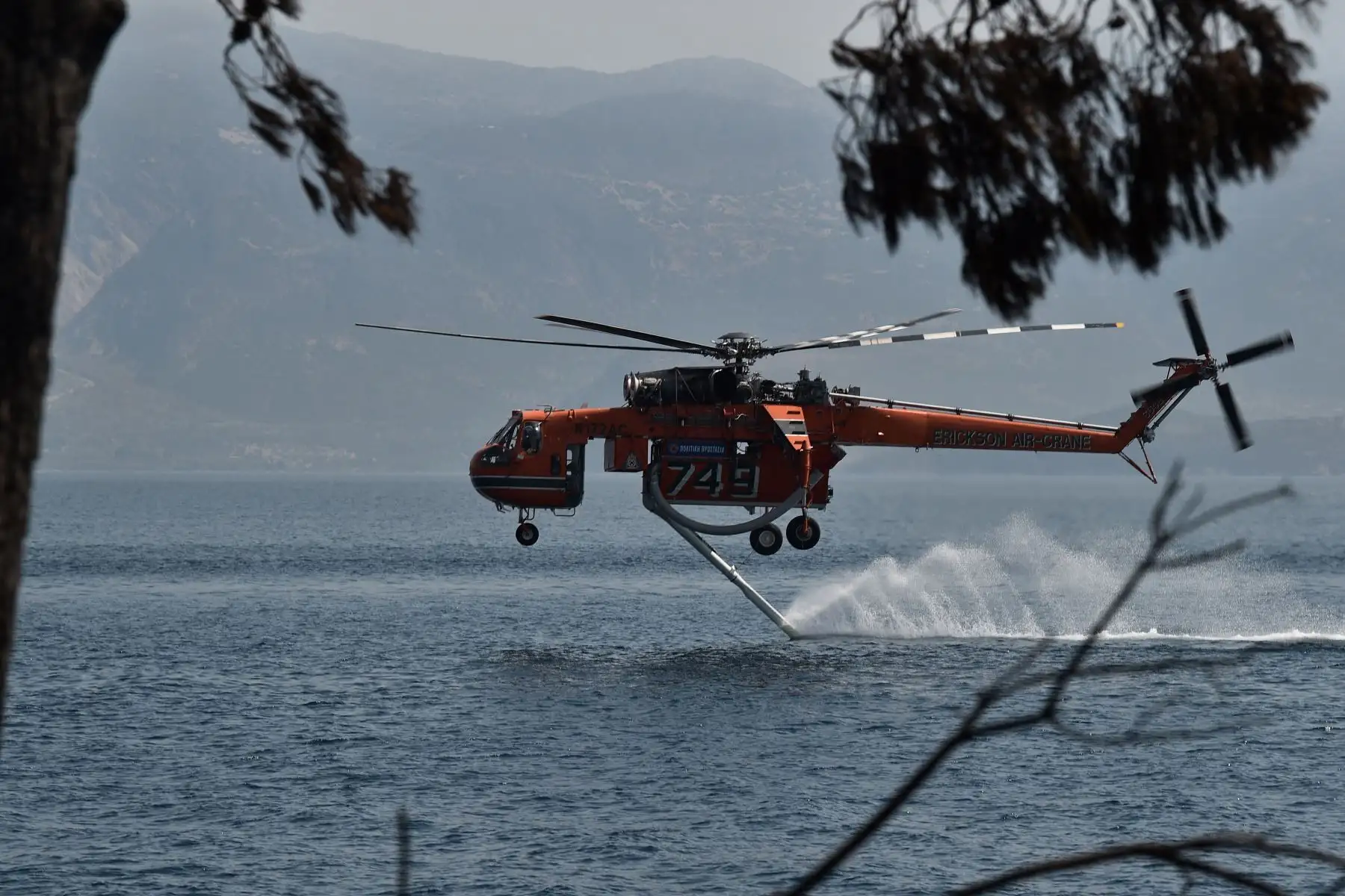 Un helicóptero Sikorsky S-64 Skycrane regresa al océano para llenarse de agua mientras lucha contra incendios cerca de la playa Lambiri cerca de Patras en Grecia. 
Foto : AFP