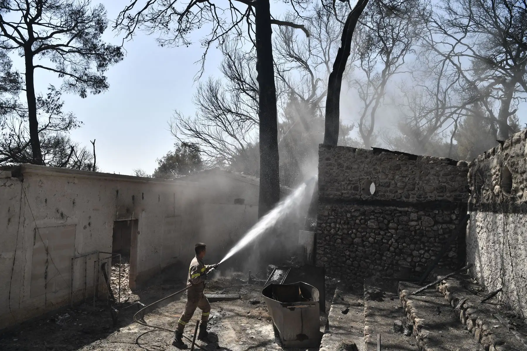 Un bombero limpia el trabajo en el área quemada de un Club Mediterranee abandonado en Lambiri, al este de Patras.
Foto: AFP