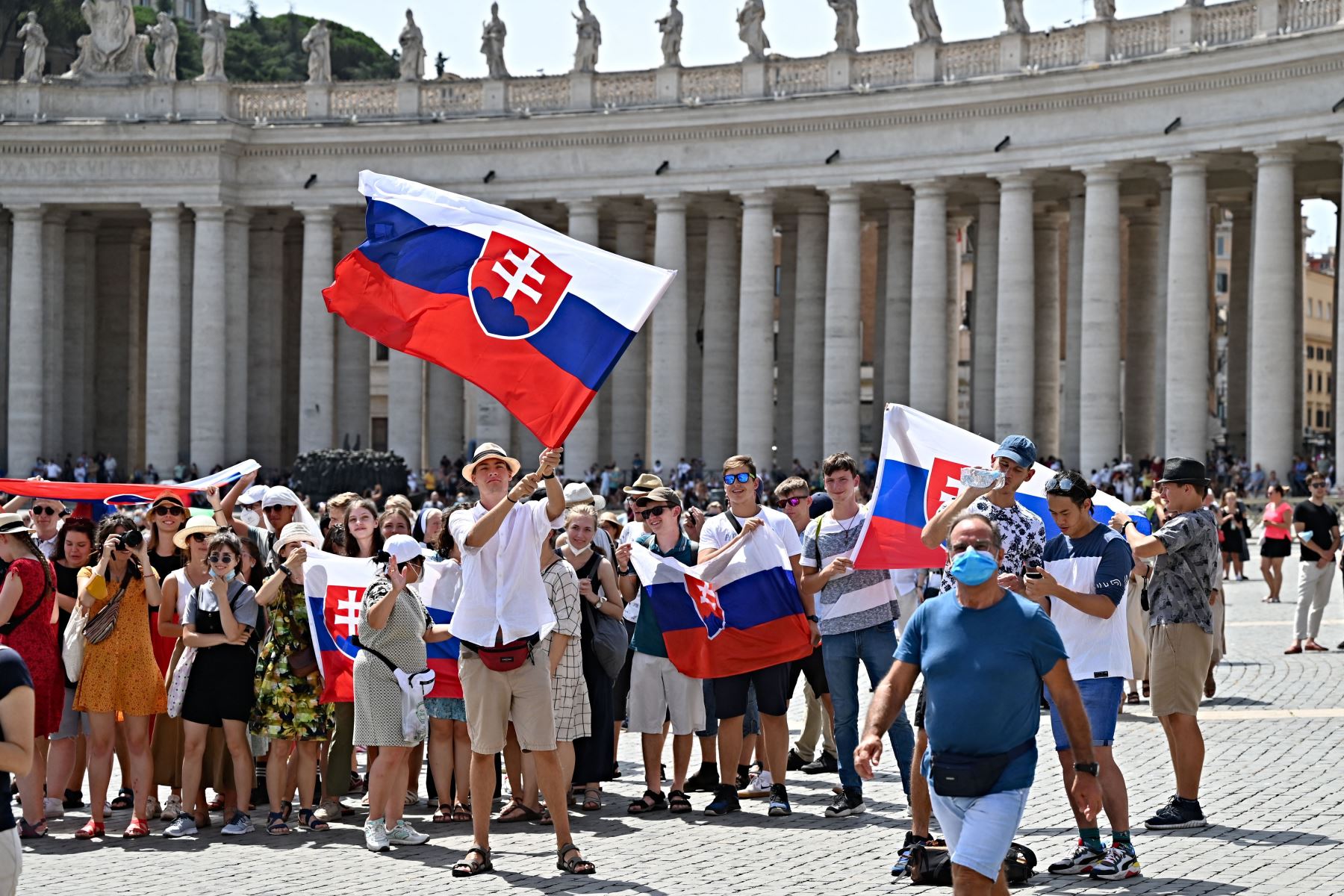 Los peregrinos eslovenos sostienen sus banderas nacionales mientras el Papa Francisco pronuncia la oración del Ángelus dominical desde la ventana de su estudio con vista a la Plaza de San Pedro en el Vaticano.
Foto: AFP