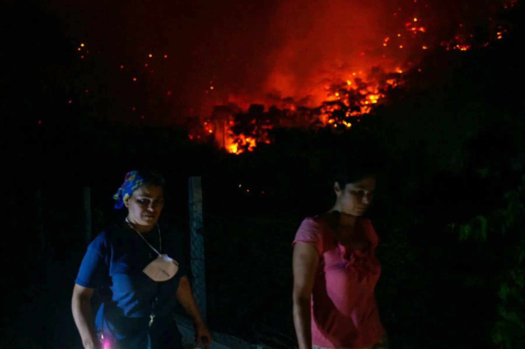 Las mujeres se alejan de los incendios forestales en el área rural de Marmaris, distrito de Mugla. Se informó que al menos tres personas murieron y más de 100 resultaron heridas mientras los bomberos luchaban contra incendios que envolvían una región turística del Mediterráneo en Costa sur de Turquía.

Foto: AFP