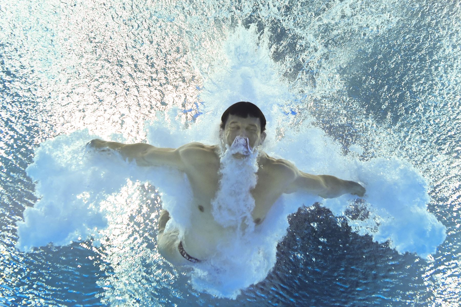 Nikita Shleikher de Rusia nadando después de completar su inmersión en la ronda preliminar del evento de salto de trampolín de 3 metros masculino durante los Juegos Olímpicos de Tokio 2020 en el Centro Acuático de Tokio.
Foto: AFP