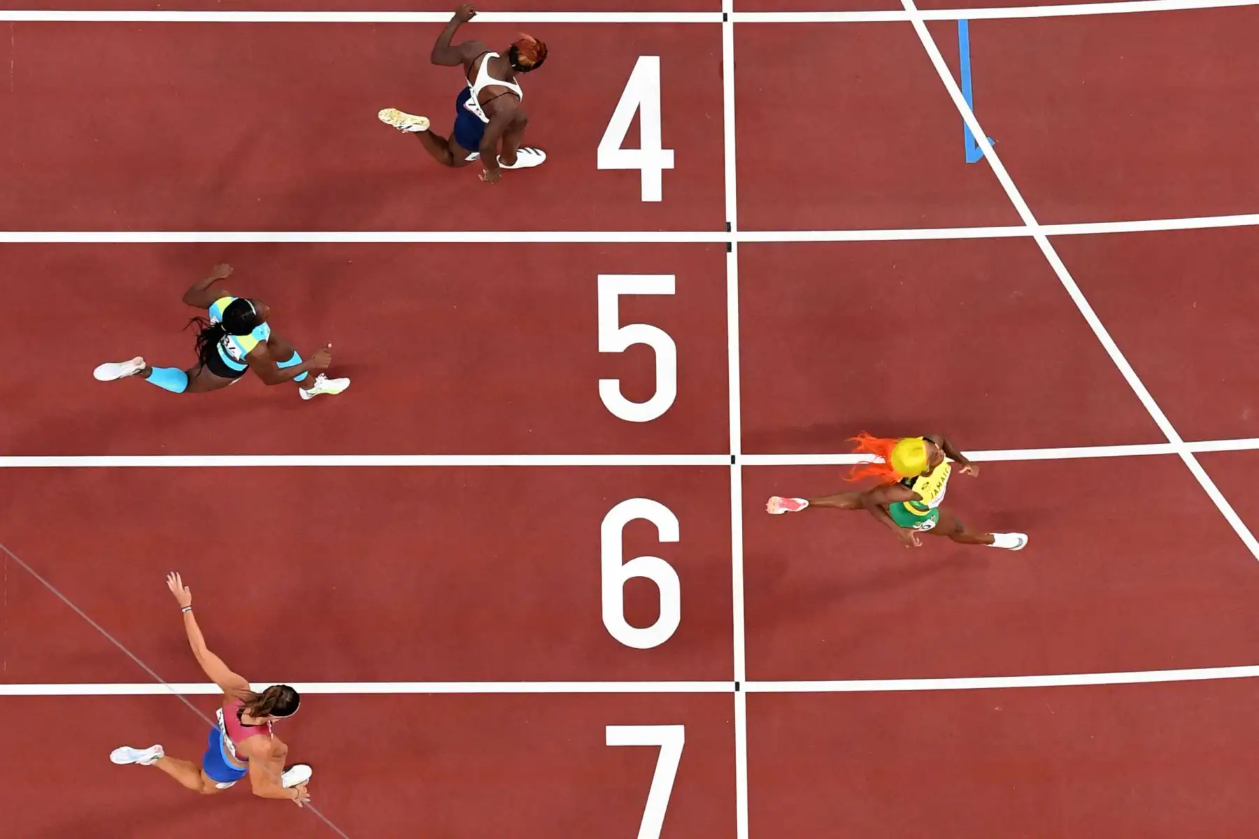 Shelly-Ann Fraser-Pryce de Jamaica gana las semifinales femeninas de 200 metros flanqueada por la estadounidense Jenna Prandini, Anthonique Strachan de Bahamas y Beatrice Masilingi de Namibia (ARRIBA) durante los Juegos Olímpicos de Tokio 2020 en el estadio olímpico de Tokio.
Foto: AFP