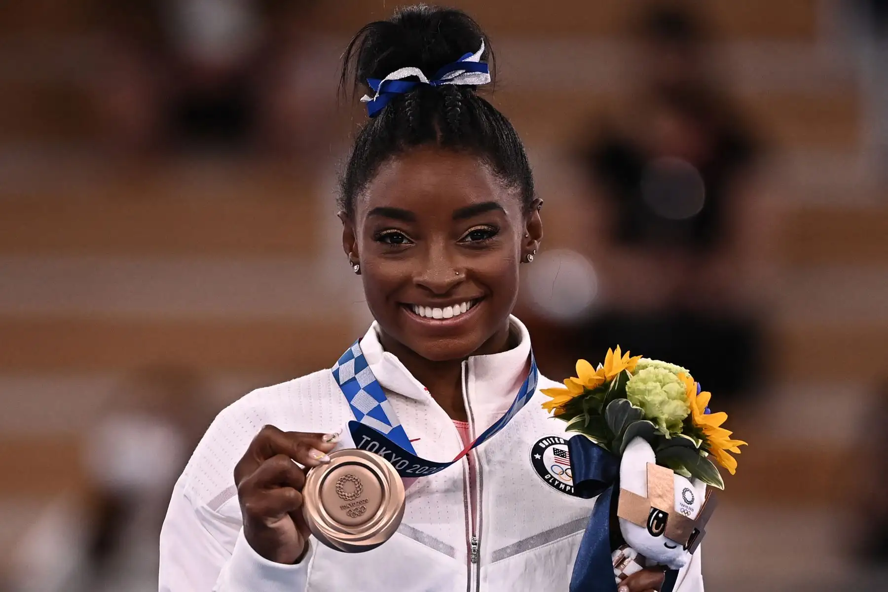La estadounidense Simone Biles posa con su medalla de bronce durante la ceremonia del podio de la barra de equilibrio femenina de gimnasia artística de los Juegos Olímpicos de Tokio 2020.

Foto: AFP