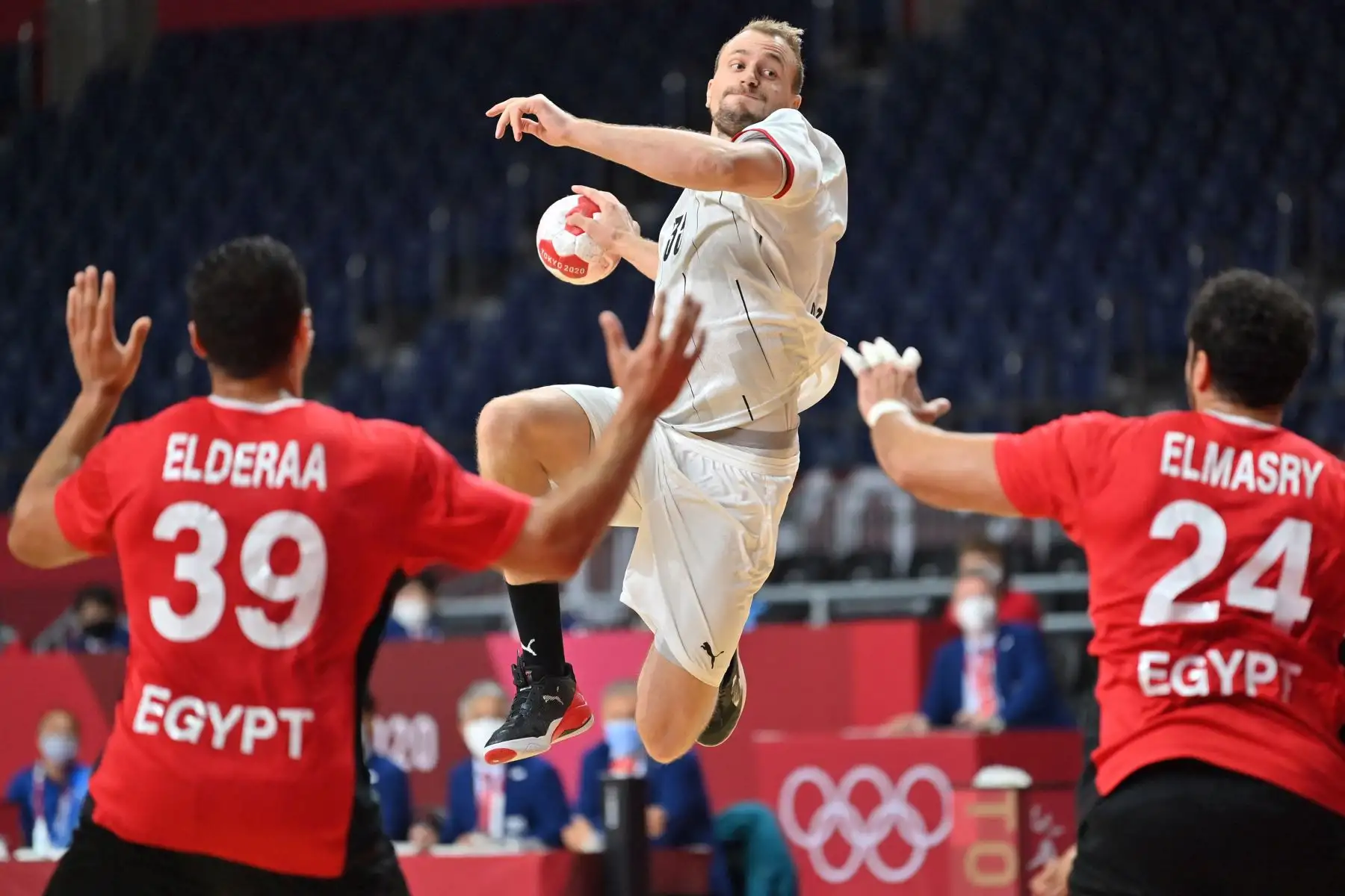 El lateral izquierdo alemán Julius Kuhn (C) salta para disparar durante el partido de balonmano masculino de cuartos de final entre Alemania y Egipto de los Juegos Olímpicos de Tokio 2020.

Foto: AFP