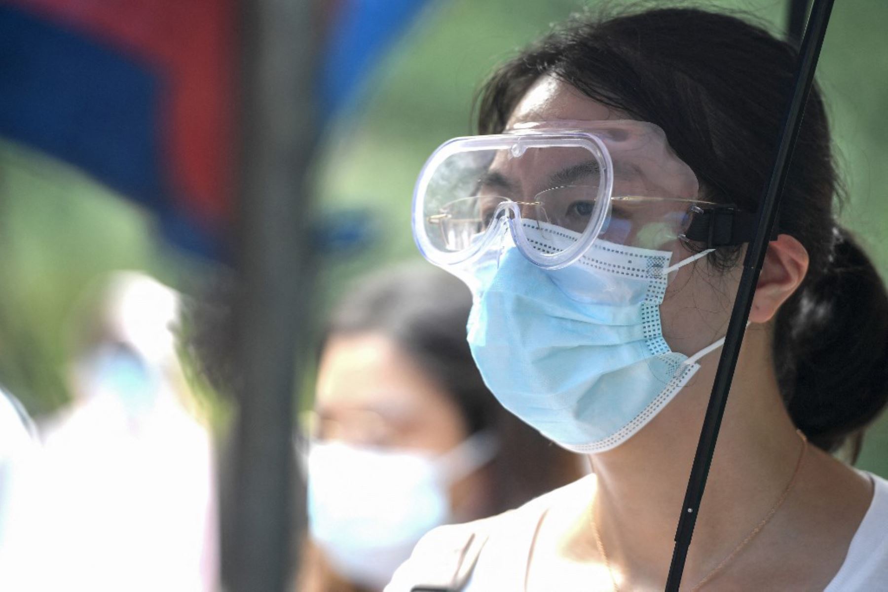 Una residente usa anteojos protectores mientras se prepara para someterse a una prueba de ácido nucleico para el coronavirus en Wuhan, en la provincia central de Hubei, en China

Foto:AFP