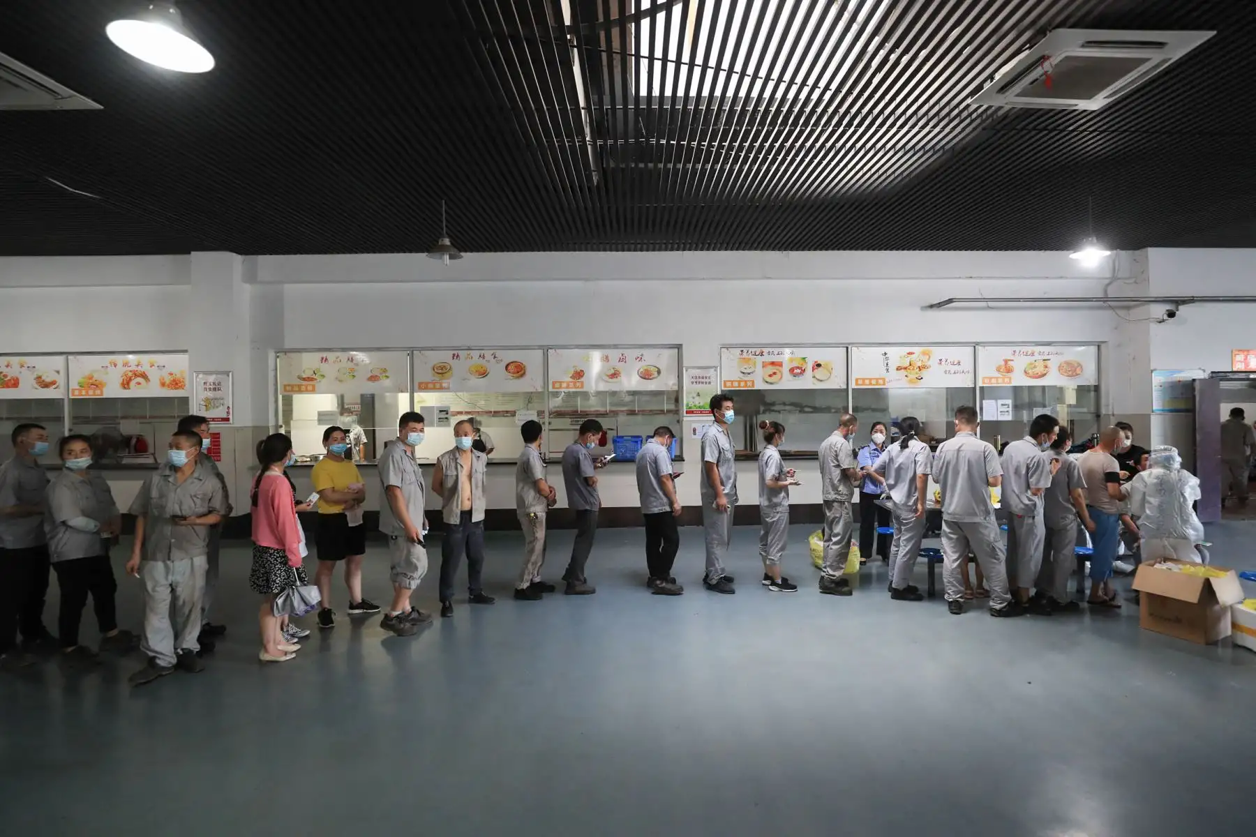 Los trabajadores hacen cola para realizar la prueba del coronavirus en el comedor de una fábrica de piezas de automóviles en Wuhan, en la provincia central de Hubei, en China.
Foto: AFP